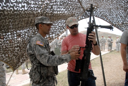 A visiting employer checks out the finer points of a Soldier's weapon during Boss Lift, an event where employers get a close look at the lives of Airmen and Soldiers