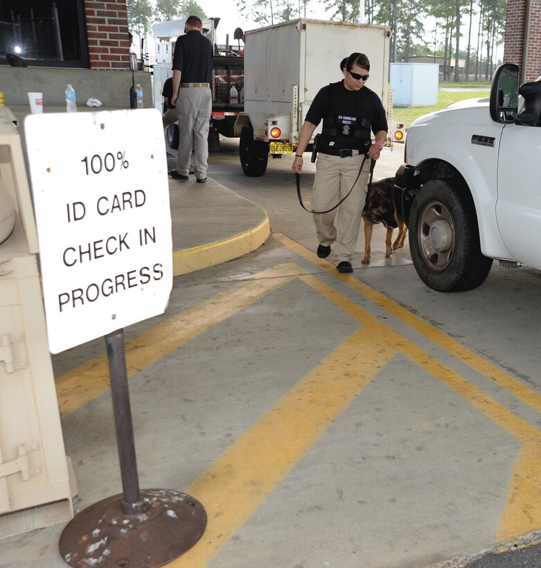 Cpl. Tonie Gezzi, police officer/K-9 handler, Marine Corps Police Department, Marine Corps Logistics Base Albany, and her working dog, Meta, walk the perimeter of a commercial vehicle during a checkpoint inspection at Gate 5, recently. 