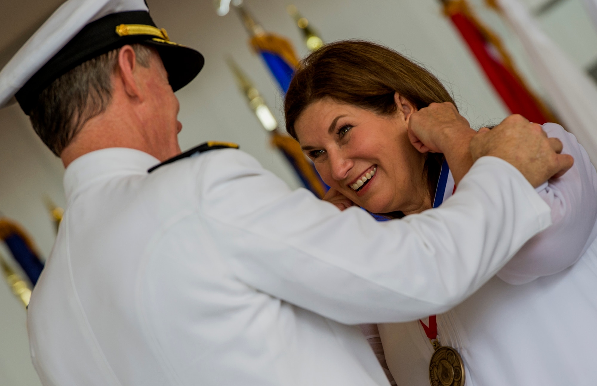 Adm. William McRaven, U.S. Special Operations Command commander, presents Donna Fiel a medal for her service to the special operations community during her husband's retirement ceremony on Hurlburt Field, Fla., July 3, 2014. Lt. Gen. Eric Fiel, former Air Force Special Operations Command commander, retired after 33 years of distinguished service. (U.S. Air Force photo by Senior Airman Christopher Callaway)