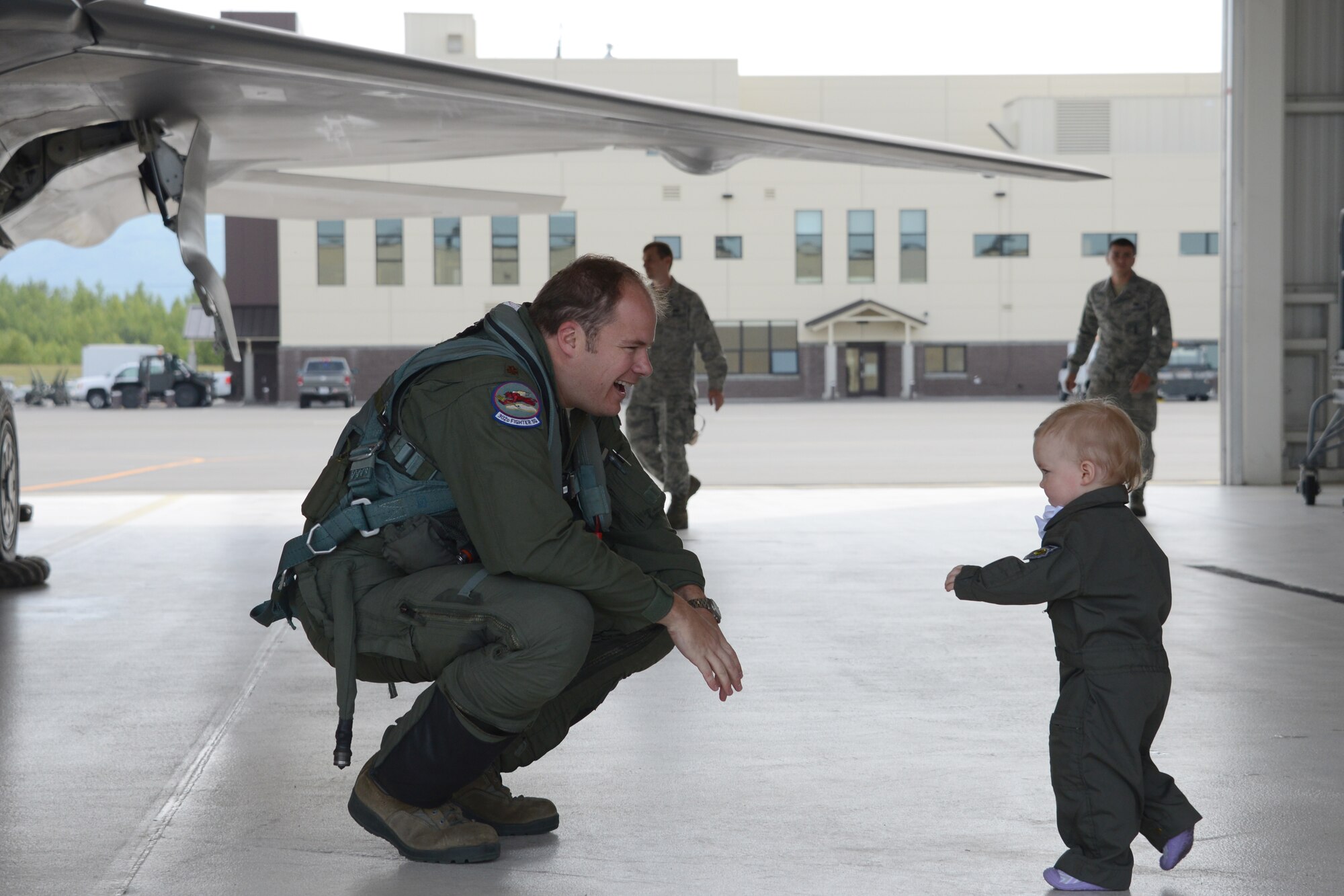 Upon landing Maj. Jonathan Gration, Reserve F-22 pilot assigned to the 302nd Fighter Squadron, is congratulated by his twin 1 year old, Madeline. This flight marked Gration’s 1,000 flight hour in the F-22 making him only the fourth Air Force pilot to reach this milestone. (U.S. Air Force photo/Tech. Sgt. Dana Rosso)
