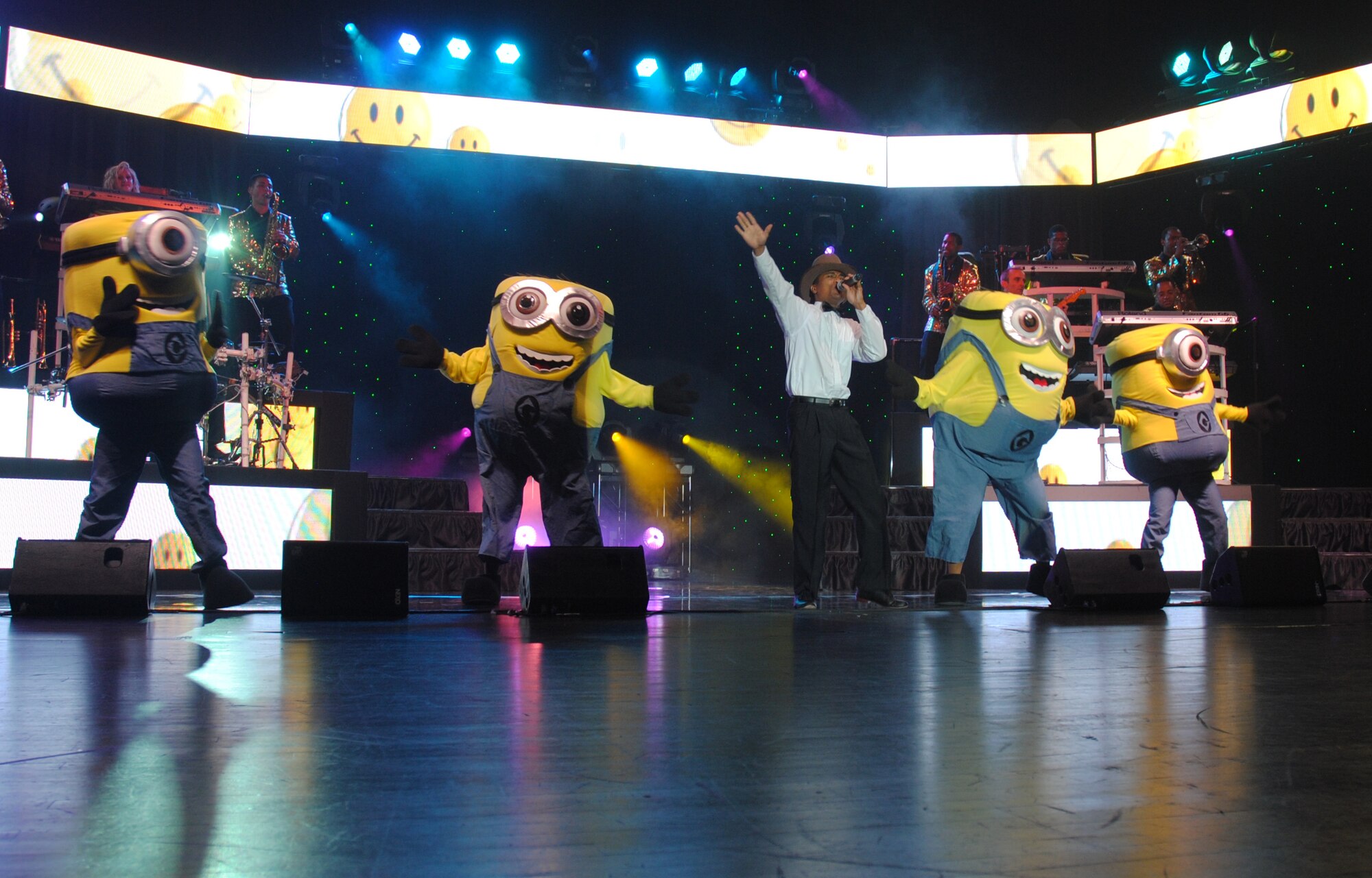 With minions as backup dancers, vocalist, Senior Airman Charles Cooper, impersonates Grammy award winning artist, Pharrel Williams, and sings the modern-day hit song, "Happy" during a Tops in Blue show held June 29, 2014, at the Chester Fritz Auditorium in Grand Forks, N.D. Tops in Blue delivered well on their commitment to entertain guests of all ages as their musical program also included songs such as, “Happy” and, “Let it go” featured on the soundtrack of popular Disney films such as Despicable Me and Frozen respectively. (U.S. Air Force photo/Staff Sgt. Luis Loza Gutierrez)