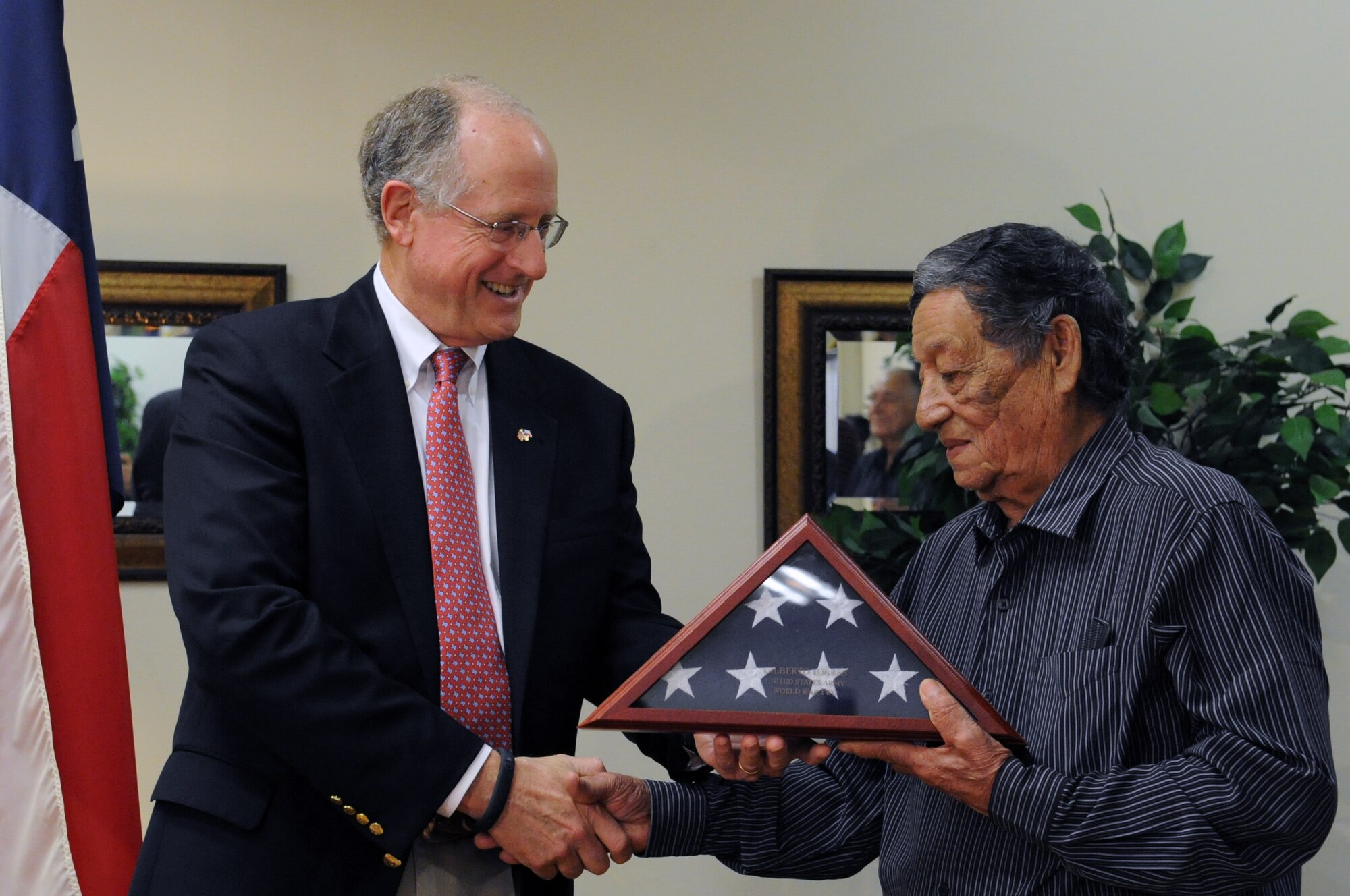 SAN ANGELO, Texas -- Rep. Mike Conaway, 11th District of Texas, presents Gilberto R. Torres, World War II veteran, with a U.S. flag that flew over the Capital May 17, during a ceremony here July 2. The flag flew in honor of Torres’ service in France during World War II. (U.S. Air Force photo/ Staff Sgt. Laura R. McFarlane)