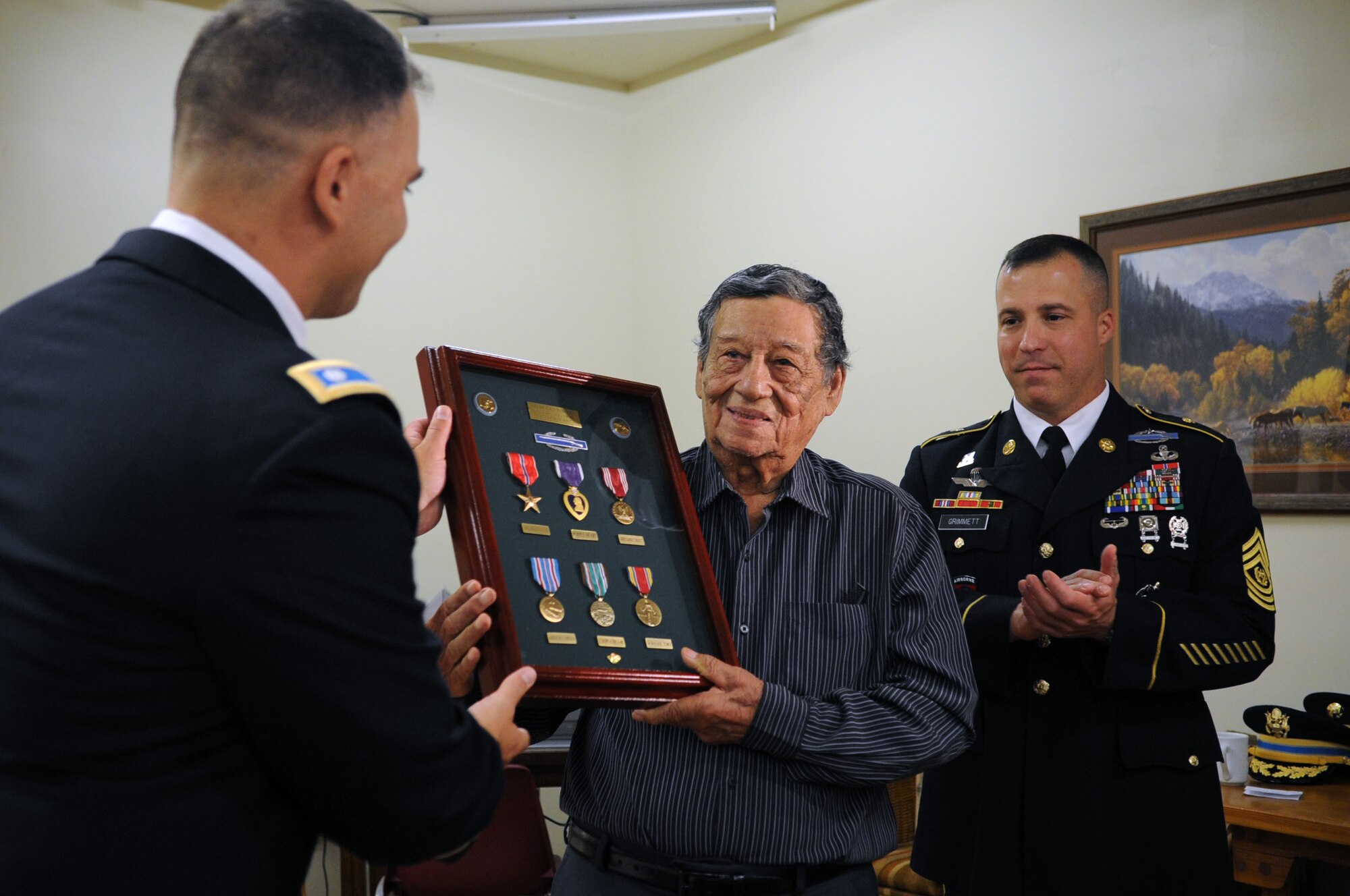 SAN ANGELO, Texas -- Army Lt. Col. Jason D. Hallock, 344th Military Intelligence Battalion Commander, and Command Sgt. Maj. Naamon J. Grimmett, present Gilberto R. Torres, a World War II veteran, with a shadowbox of Torres’ decorations during a ceremony here July 2. During his time in service, Torres earned the Bronze Star, Purple Heart, Good Conduct Medal, American Campaign Medal, European-African-Middle Eastern Campaign Medal, Victory Medal, Combat Infantryman Badge and Honorable Service Lapel. (U.S. Air Force photo/ Staff Sgt. Laura R. McFarlane)