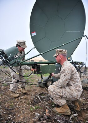 U.S. Marine Corps Sgts. Destini Brown and Nicholas Perez, Marine Wing Communications Squadron 38 satellite operators assigned to Marine Corps Air Station Cherry Point, N.C., fix the cabling on an a Very Small Aperture Terminal Medium during Red Flag-Alaska 14-2 June 24, 2014, Joint Pacific Alaska Range Complex, Alaska. The VSAT-M is used for secure and non-secure data and telephone services. (U.S. Air Force photo by Senior Airman Ashley Nicole Taylor/Released)