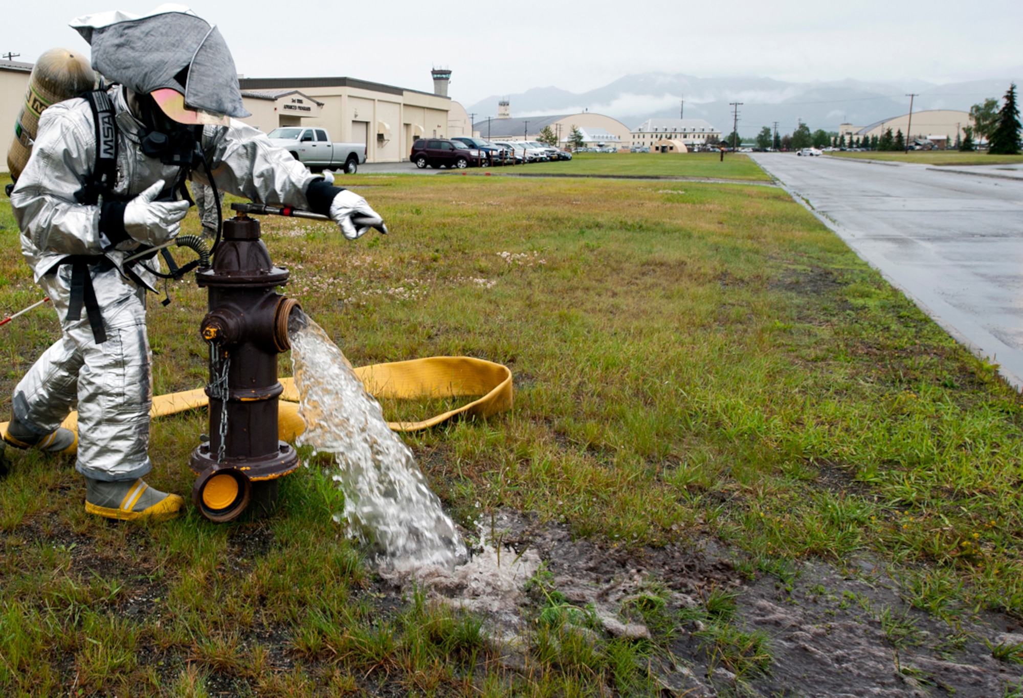A firefighter with the 673d Civil Engineer Squadron opens a fire hydrant to put out a fire after a simulated explosion during the annual mission assurance exercise on Joint Base Elmendorf-Richardson, Alaska, June 26, 2014. Organizations such as the 673d Medical Group, Security Forces Squadron and Civil Engineer Squadron were the first responders on the scene of a simulated explosion. (U.S. Air Force photo/Airman 1st Class Tammie Ramsouer)