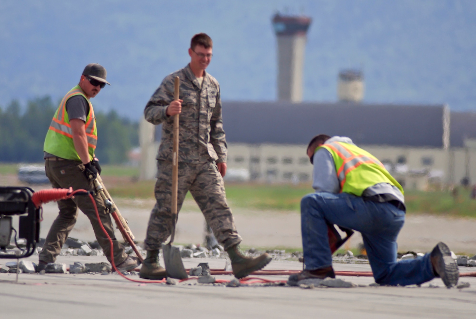 Ernest Scarborough,left, Tech Sgt. Johnathon Stone, and Michael Nicholes perform maintenance on the Joint Base Elmendorf-Richardson, Alaska, flightline, Tuesday, July 1, 2014. JBER's primary runway, which runs east-to-west, is undergoing annual repairs until approximately July 18.  As with roadways across the state, the Alaska climate often accelerates damage to airfield surfaces. The JBER airfield has only a four-month period, June through September, to conduct airfield runway, taxiway and ramp repair. The runway is used in more than two-thirds of JBER flights as it allows for the least noise impact on the greater Anchorage community. Residents near Joint Base Elmendorf-Richardson may notice heightened noise levels during this time as aircraft utilize the north-south runway. (U.S. Air Force photo/Justin Connaher)