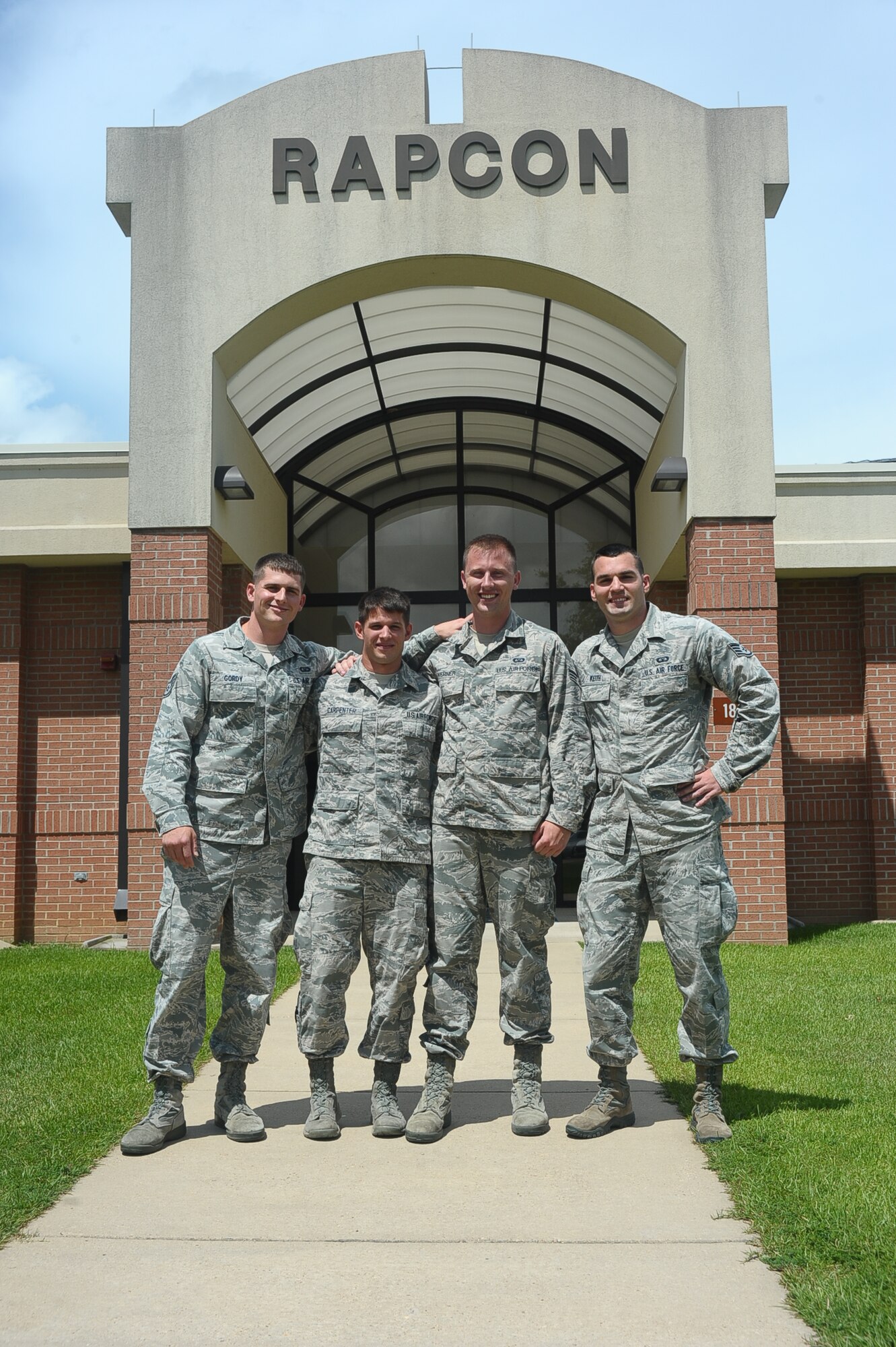 Staff Sgt. Alexander Gordy, Airman 1st Class Kyle Carpenter, Senior Airman Ryan Werner and Staff Sgt. Joshua Keith, 14th Operations Support Squadron, pose for a photo June 24 outside their place of work, the Radar Approach Control. The Airmen demonstrated the Air Force Core Value of Service Before Self by saving a drowning man, May 26, 2014, at the Buttahatchee river in Caledonia, Miss. (U.S. Air Force photo/ Airman John Day)