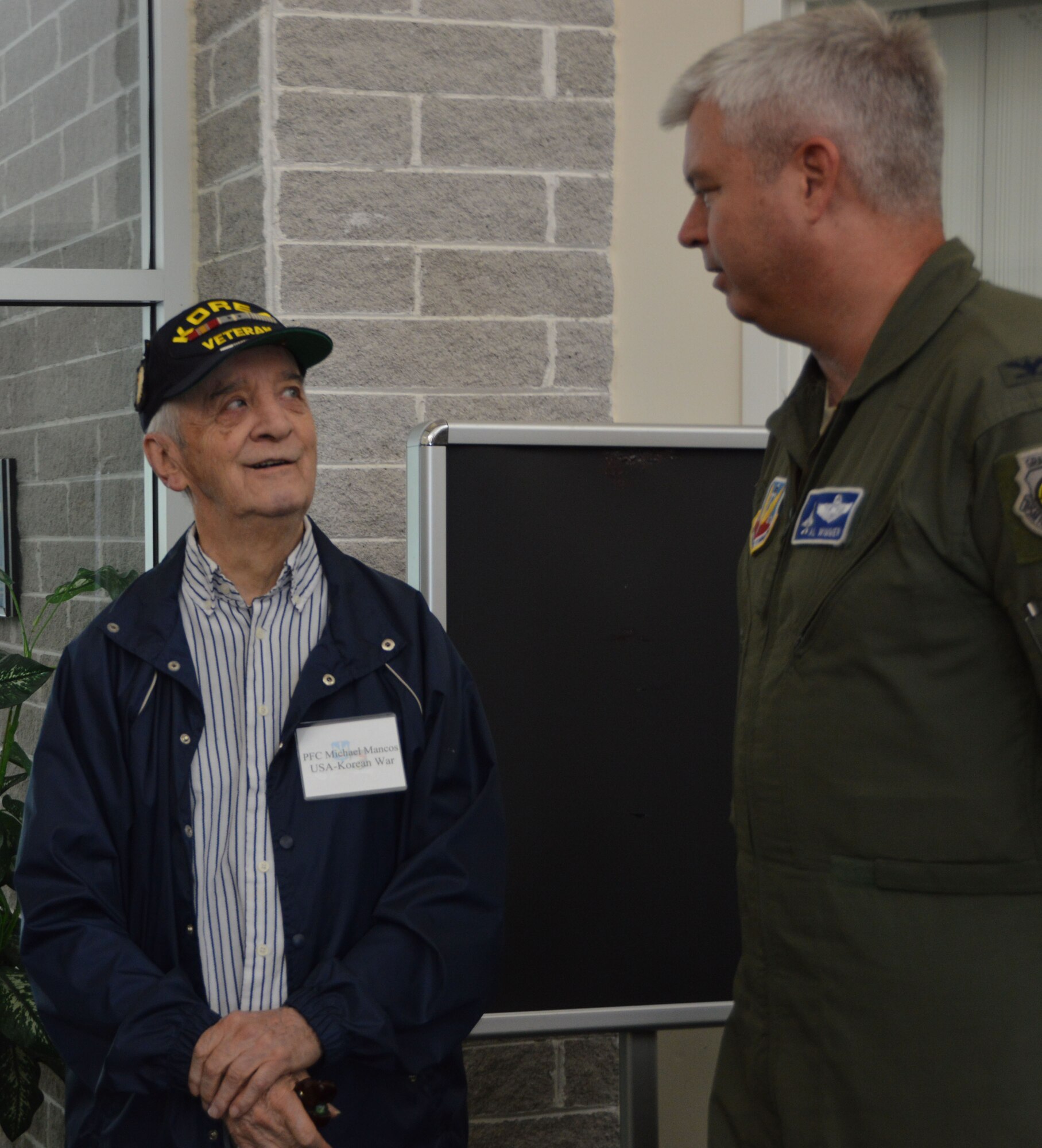 Michael Mancos, a former U.S. Army Private First Class who served in the Korean War, meets his reception escort, Col. Al Wimmer, Director, Air, Space and Information Operations. (Photo by Mary McHale)