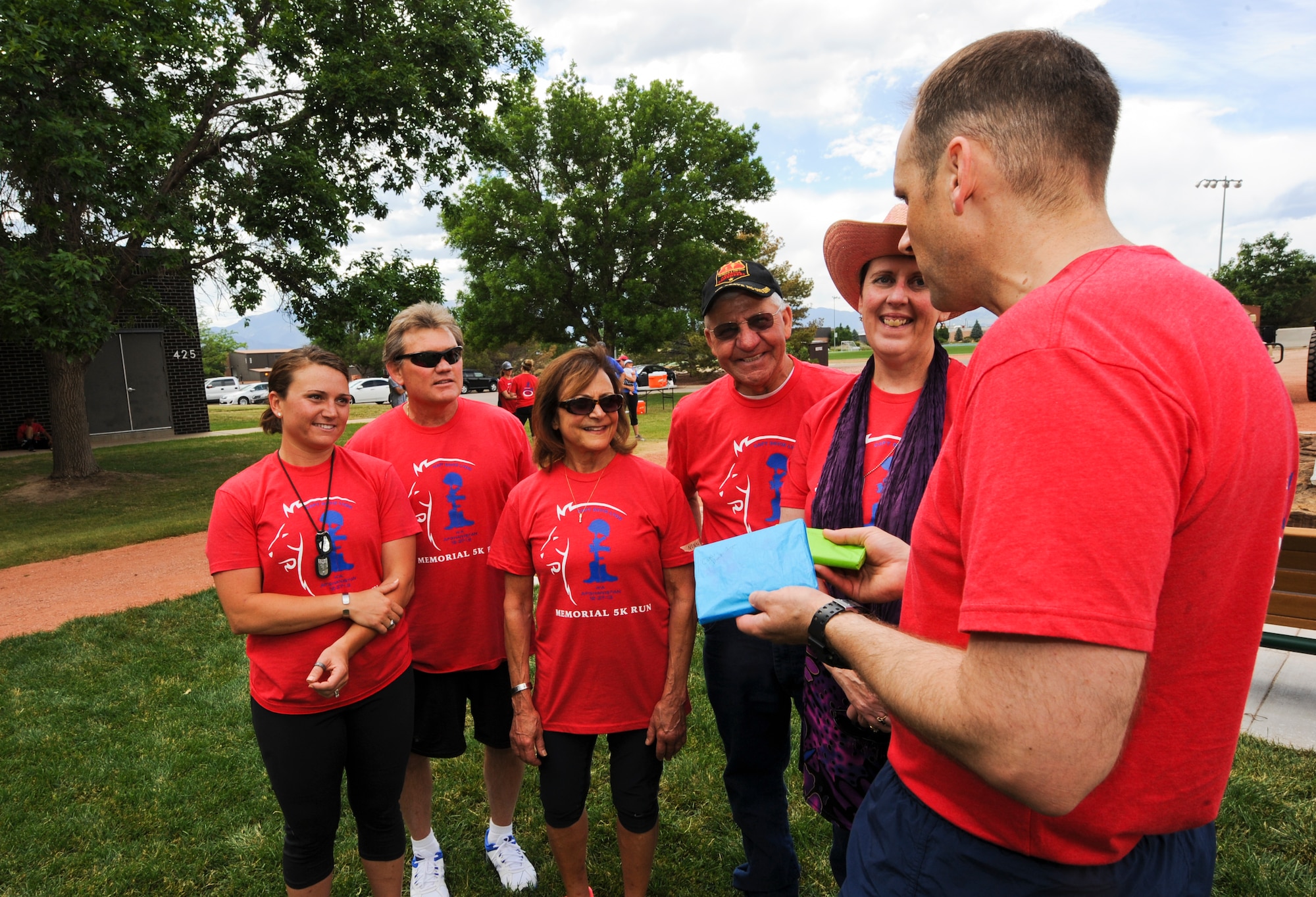PETERSON AIR FORCE BASE, Colo. – The Lyon and Pounds families receive coins and photographs from Lt. Col. Jim Lovewell, the former logistics readiness squadron commander for Capt. David Lyon, June 27. The coins and photos were from a memorial run at Thule Air Base, Greenland, held May 25. Lyon was killed in action Dec. 27, 2013, in Afghanistan. (U.S. Air Force photo/Staff Sgt. Jacob Morgan)