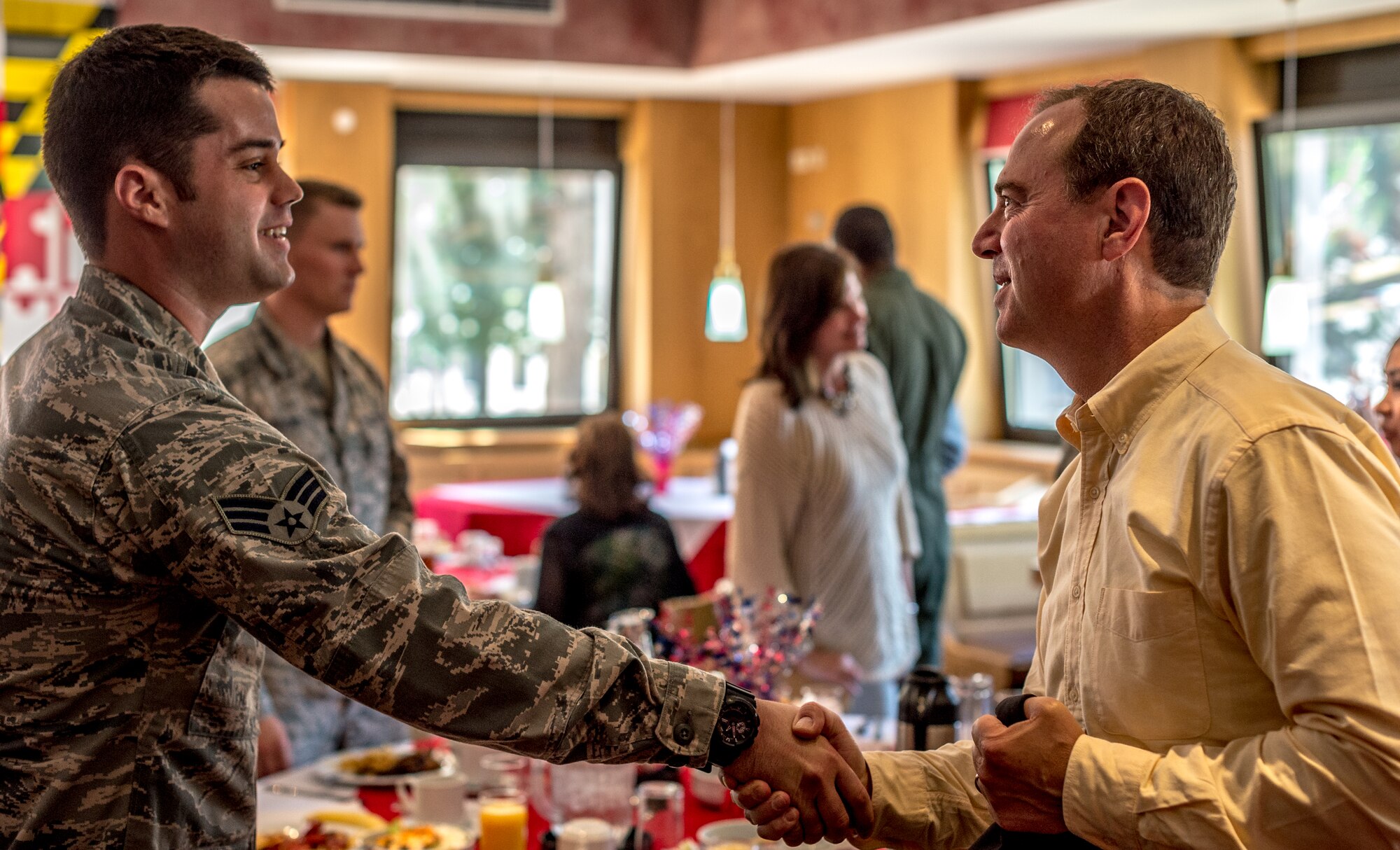 Senior Airman Brent Heasell, 603rd Air and Space Operations Center intelligence analyst, shakes hands with U.S. Rep. Adam Schiff at a luncheon held at Ramstein Air Base, Germany, July 3. Schiff and five other members of Congress made a brief stop here to meet with Airmen from their home states stationed at Ramstein. (U.S. Air Force photo/ Airman 1st Class Jordan Castelan)