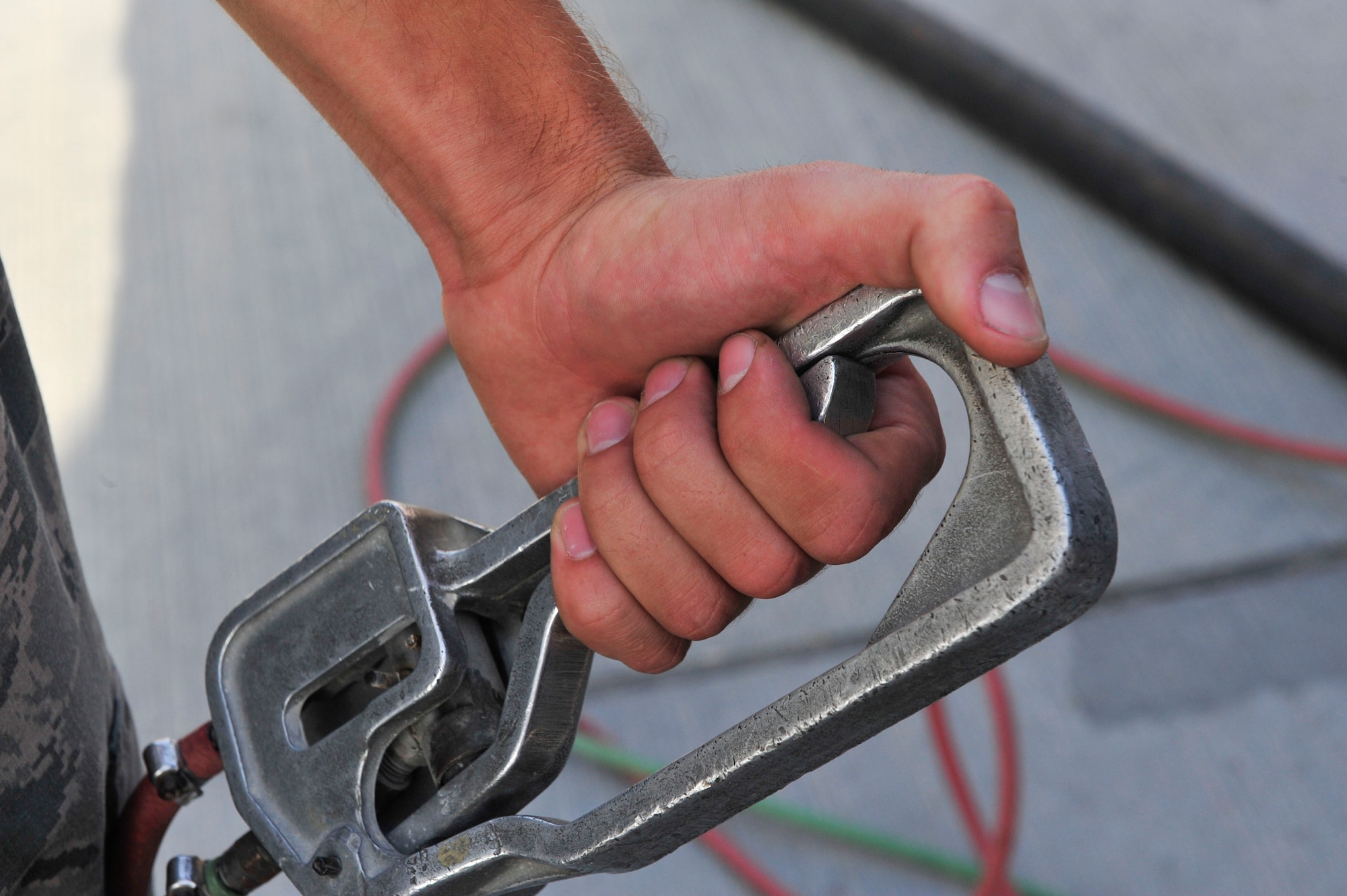 U.S Air Force Senior Airman Kyle Schmitt, 379th Expeditionary Logistics Readiness Squadron fuels distribution operator, holds the emergency fuel switch at Al Udeid Air Base, Qatar, June 30, 2014. The 379th ELRS fuels distribution operators pump nearly 850,000 gallons of JP-8 in a day, making it the busiest fuels hub in the Department of Defense. Schmitt is deployed from Joint Base McGuire-Dix-Lakehurst, New Jersey, and his hometown is Toms River, New Jersey. (U.S. Air Force photo by Senior Airman Colin Cates)