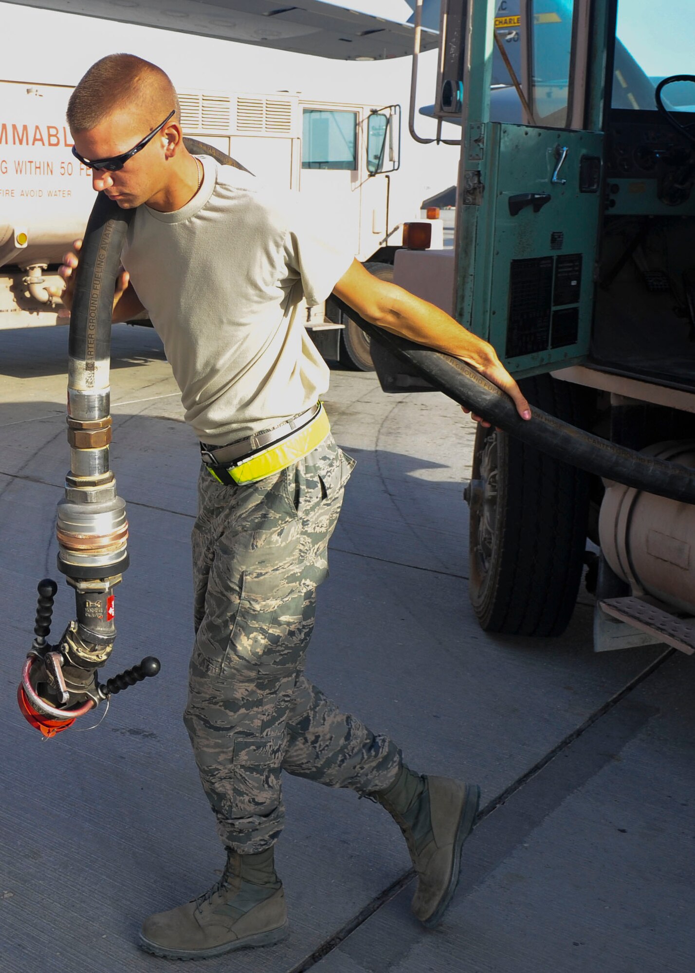 U.S. Air Force Senior Airman Kyle Schmitt, 379th Expeditionary Logistics Readiness Squadron fuels distribution operator, unreels a fuel hose prior to fueling a C-17 Globemaster III at Al Udeid Air Base, Qatar, June 30, 2014. The fuel truck holds 6,000 gallons of fuel and can pump about 600 gallons a minute. Schmitt is deployed from Joint Base McGuire-Dix-Lakehurst, New Jersey, and his hometown is Toms River, New Jersey. (U.S. Air Force photo by Senior Airman Colin Cates)