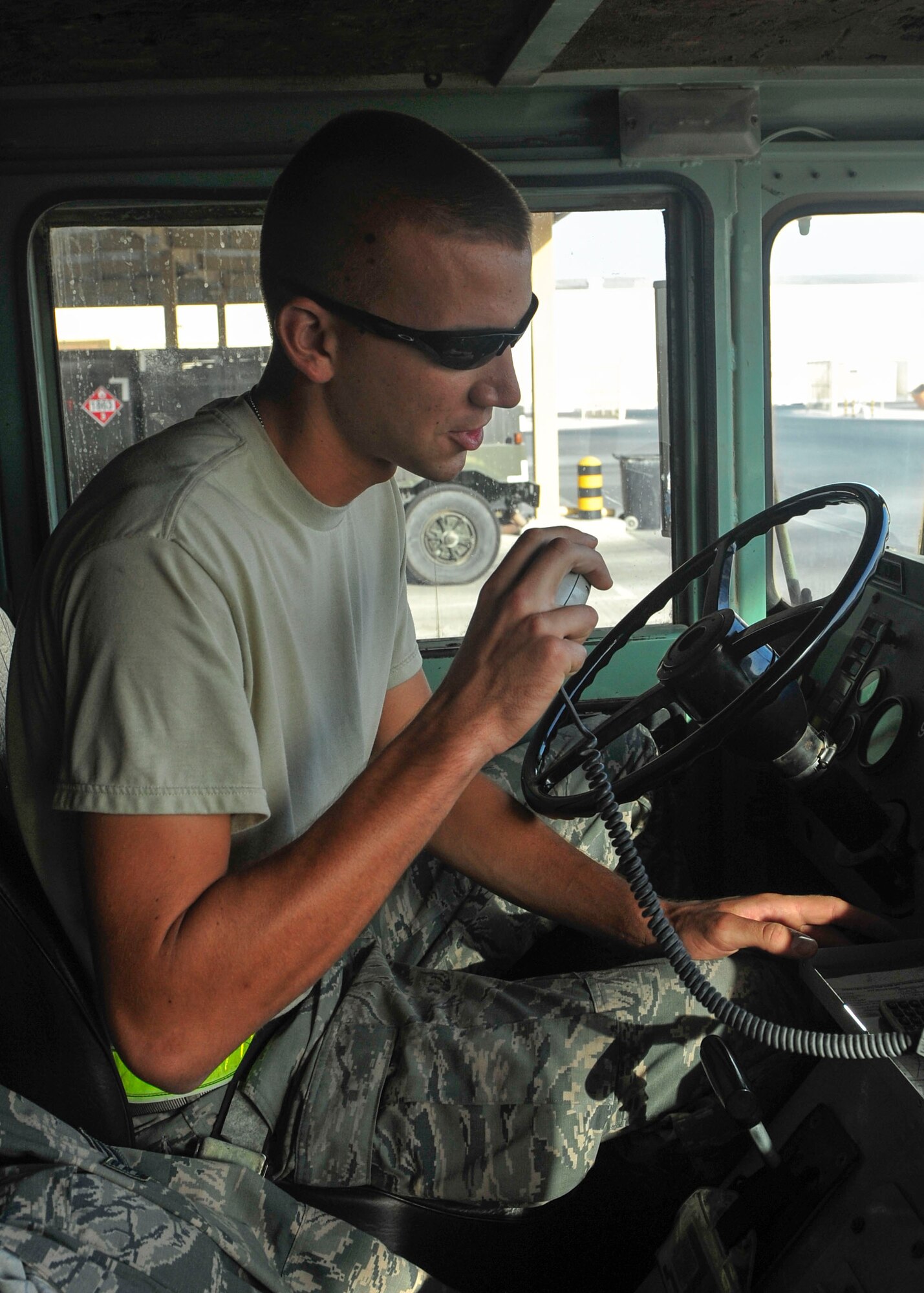 U.S. Air Force Senior Airman Kyle Schmitt, 379th Expeditionary Logistics Readiness Squadron fuels distribution operator, uses a citizens band radio at Al Udeid Air Base, Qatar, June 30, 2014. Fuels distribution operators look over fuel trucks through all pre-checks, pressurizing, checks for leaks and damage.  Schmitt is deployed from Joint Base McGuire-Dix-Lakehurst, New Jersey, and his hometown is Toms River, New Jersey. (U.S. Air Force photo by Senior Airman Colin Cates)