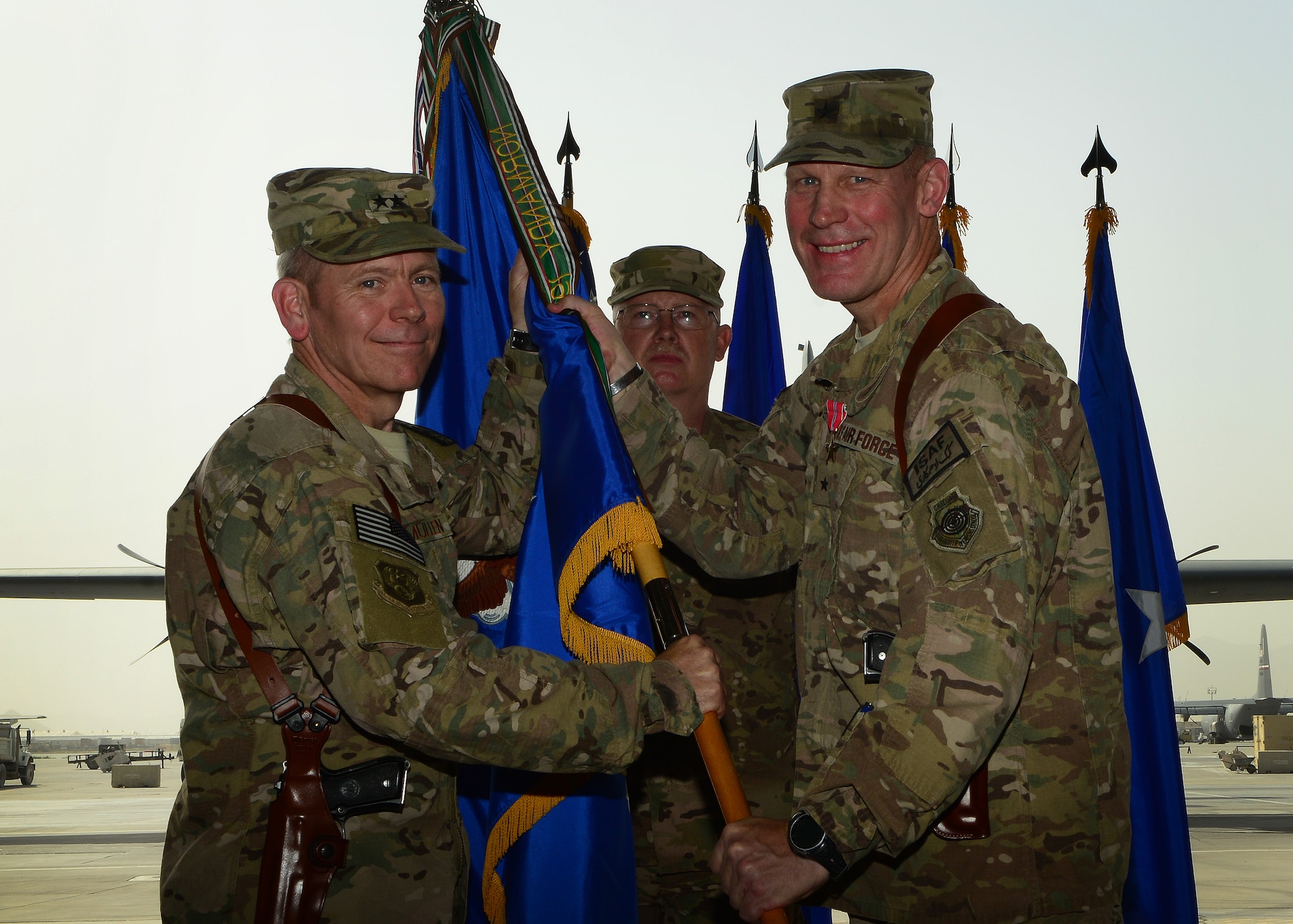U.S. Air Force Brig. Gen. Patrick Malackowski passes the 455th Air Expeditionary Wing guidon to Maj. Gen. John McMullen, 9th Air and Space Expeditionary Task Force Afghanistan commander to relinquish command during a change of command ceremony at Bagram Airfield, Afghanistan July 3, 2014. (U.S. Air Force photo by Staff Sgt. Evelyn Chavez/Released)