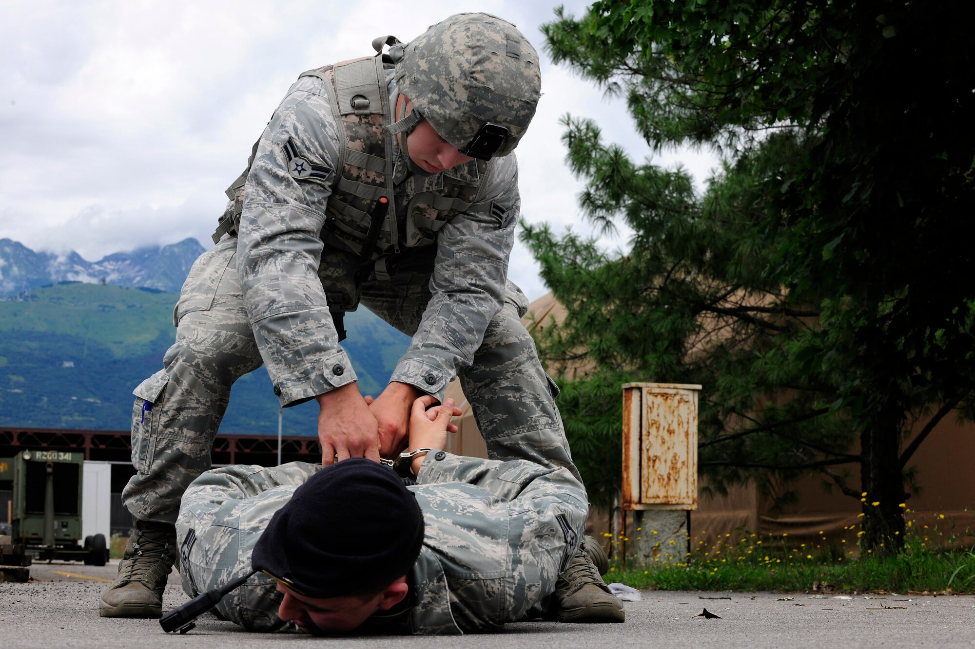 Airman 1st Class Austin McClain puts cuffs on Senior Airman Michael Schramm during a simulated gate runner exercise, July 1, 2014, at Aviano Air Base, Italy. To ensure the defenders remain highly proficient in their job, they are tested regularly with frequent exercises. McClain and Schramm are 31st Security Forces Squadron security response team members. (U.S. Air Force photo/Airman 1st Class Ryan Conroy) 