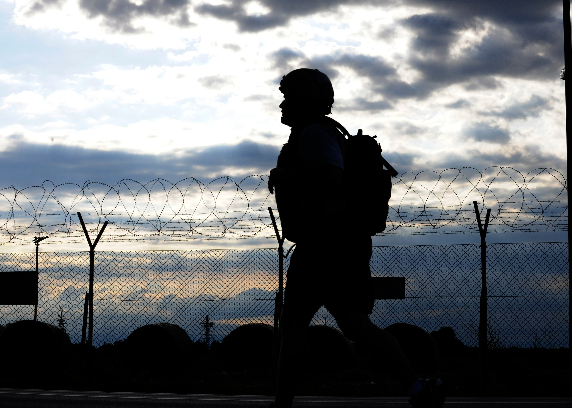A 31st Security Forces Squadron Airman runs the perimeter for an early-morning physical training session, July 1, 2014, at Aviano Air Base, Italy. Defenders ran 45 minutes in body armor and Kevlar helmets to maintain agility in combat gear. (U.S. Air Force photo/Airman 1st Class Ryan Conroy)