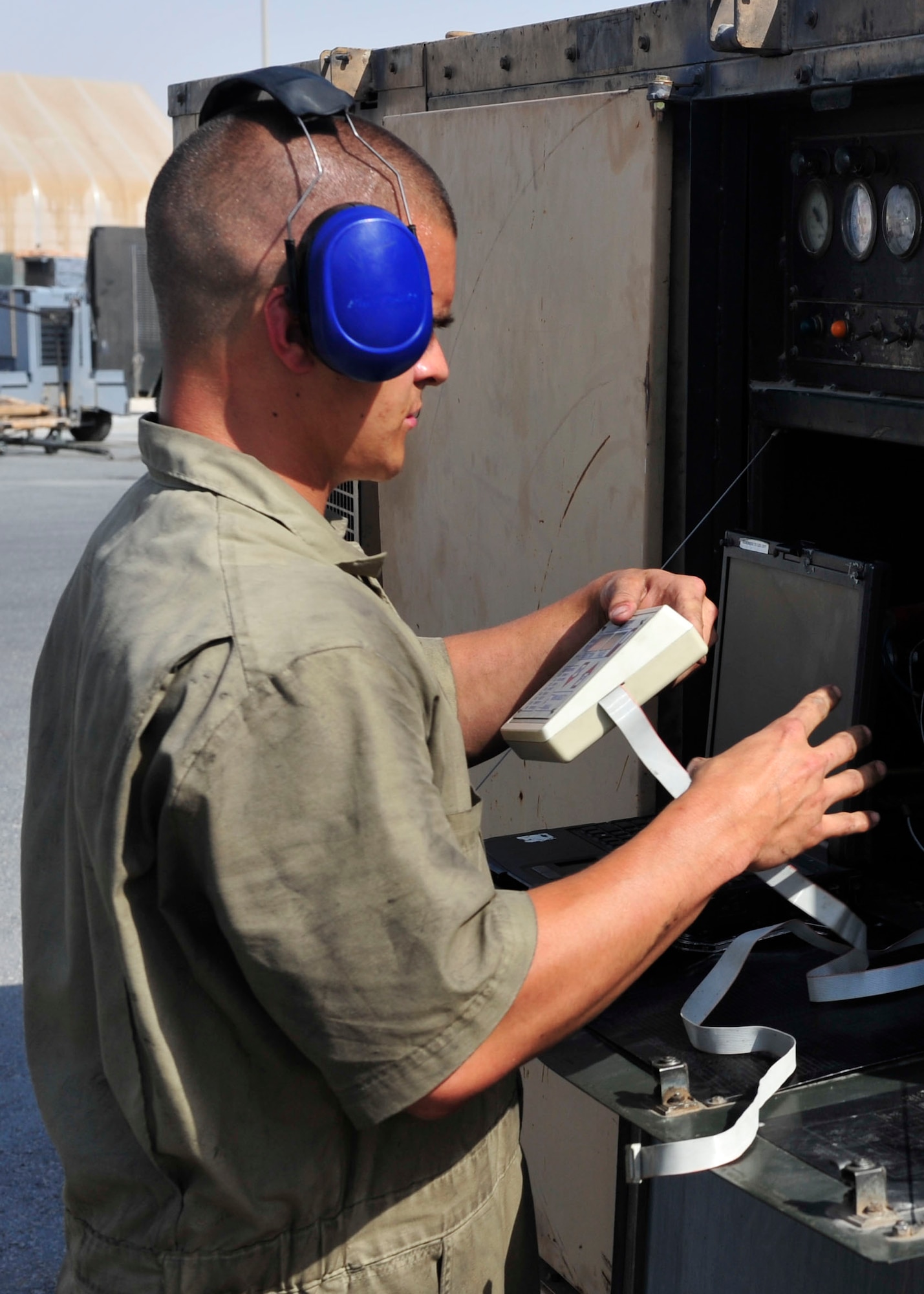 U.S. Air Force Senior Airman Kyle Taylor, 379th Expeditionary Maintenance Squadron Aerospace Ground Equipment maintenance journeyman, goes over a maintenance checklist for a generator at Al Udeid Air Base, Qatar, June 30, 2014. The AGE flight maintains 642 pieces of aerospace ground equipment valued at 30 million dollars. Taylor is deployed from Aviano Air Base, Italy and his hometown is Kenton, Ohio. (U.S. Air Force photo by Senior Airman Colin Cates) 