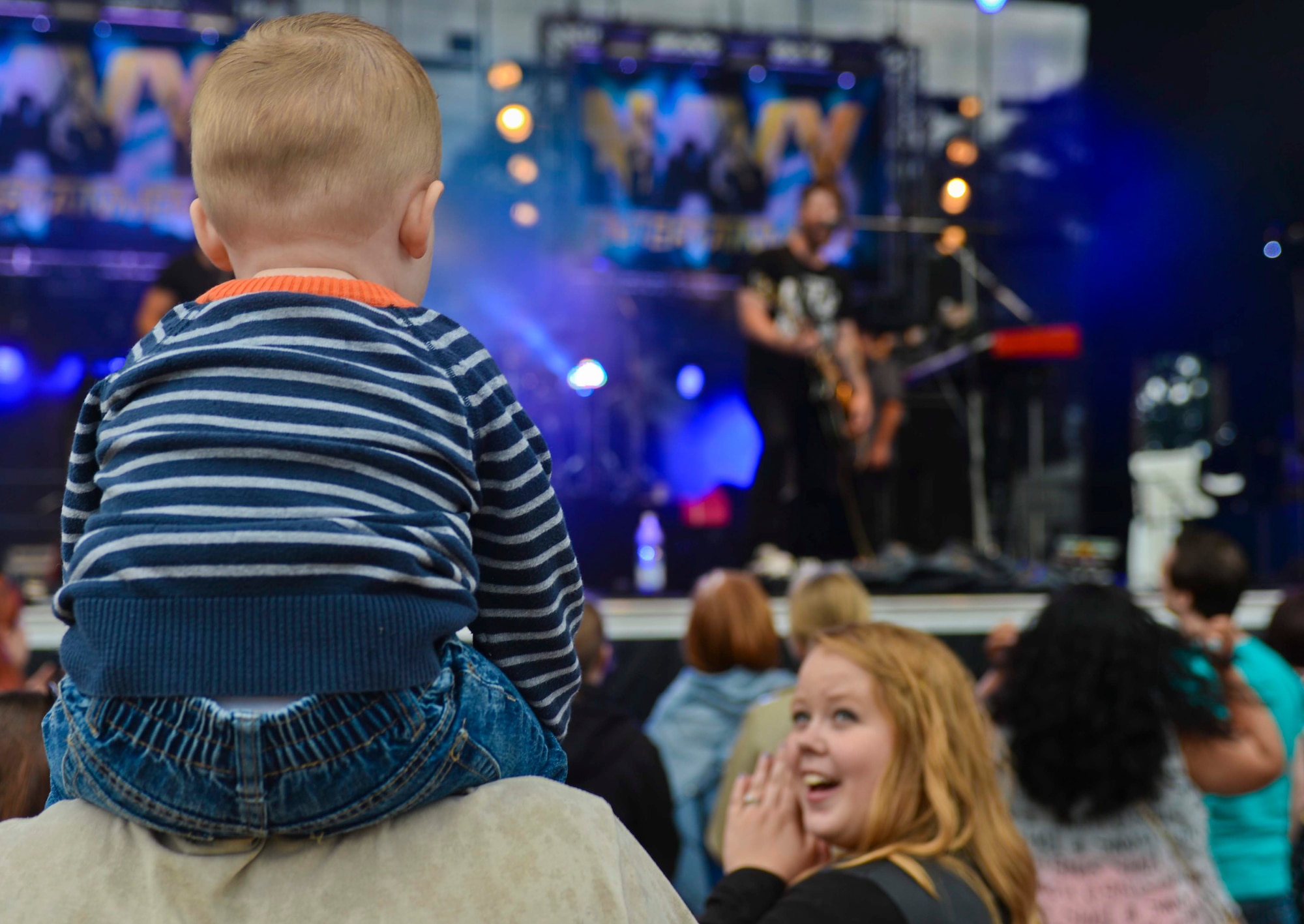 A child watches as David Cook, American Idol-winning musician, performs on the stage during the Belgian-American Friendship Day at Kleine Brogel Air Base, Belgium, June 27, 2014. Cook performed the free concert as part of his worldwide tour sponsored by Navy Entertainment and Armed Forces Entertainment. (U.S. Air Force photo by Staff Sgt. Joe W. McFadden/Released)