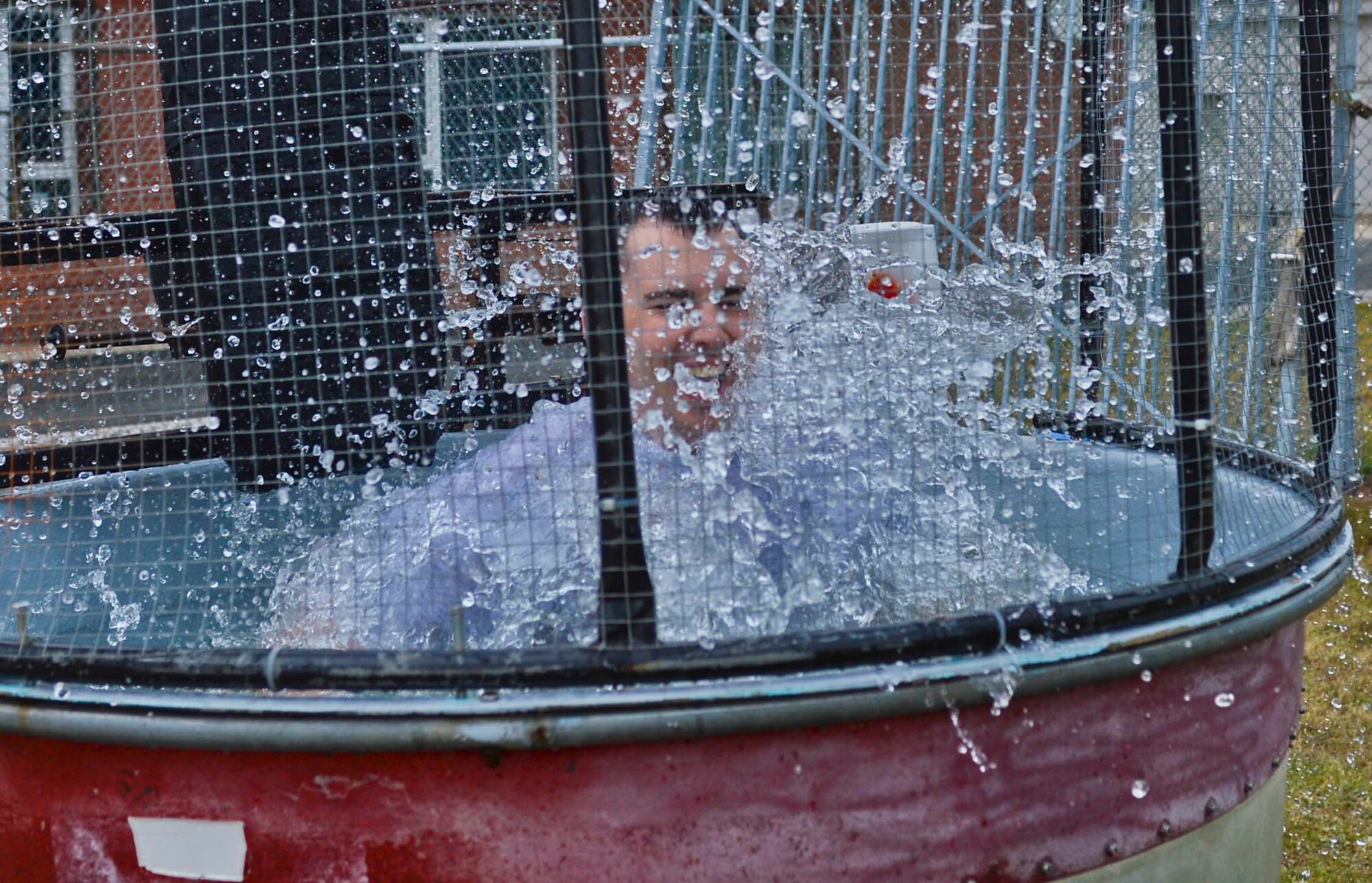 U.S. Air Force 1st Lt. Ryan VanArtsdalen, 701st Munitions Support Squadron maintenance flight commander and Hillsboro, Ore., native, falls in the dunk tank during the Belgian-American Friendship Day at Kleine Brogel Air Base, Belgium, June 27, 2014. Participants had the opportunity to dunk VanArtsdalen by either throwing a softball or kicking a soccer ball at a target connected to the booth.   (U.S. Air Force photo by Staff Sgt. Joe W. McFadden/Released)