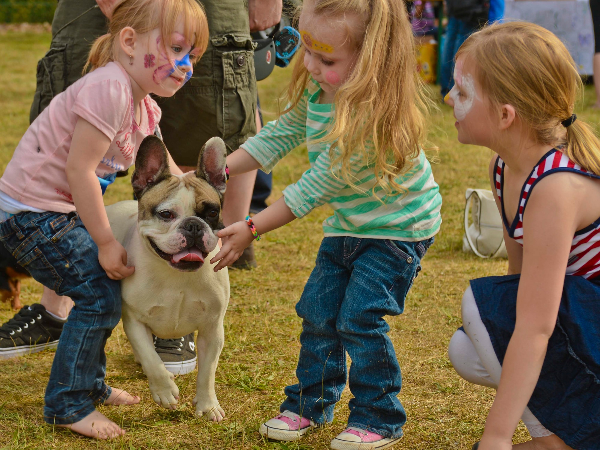 Children pet Roskoe, a French Bulldog, during the Belgian-American Friendship Day at Kleine Brogel Air Base, Belgium, June 27, 2014. Belgian and American children had opportunities to get their faces painted, play in a bouncy castle and play with Frisbees during the complementary event. (U.S. Air Force photo by Staff Sgt. Joe W. McFadden/Released)