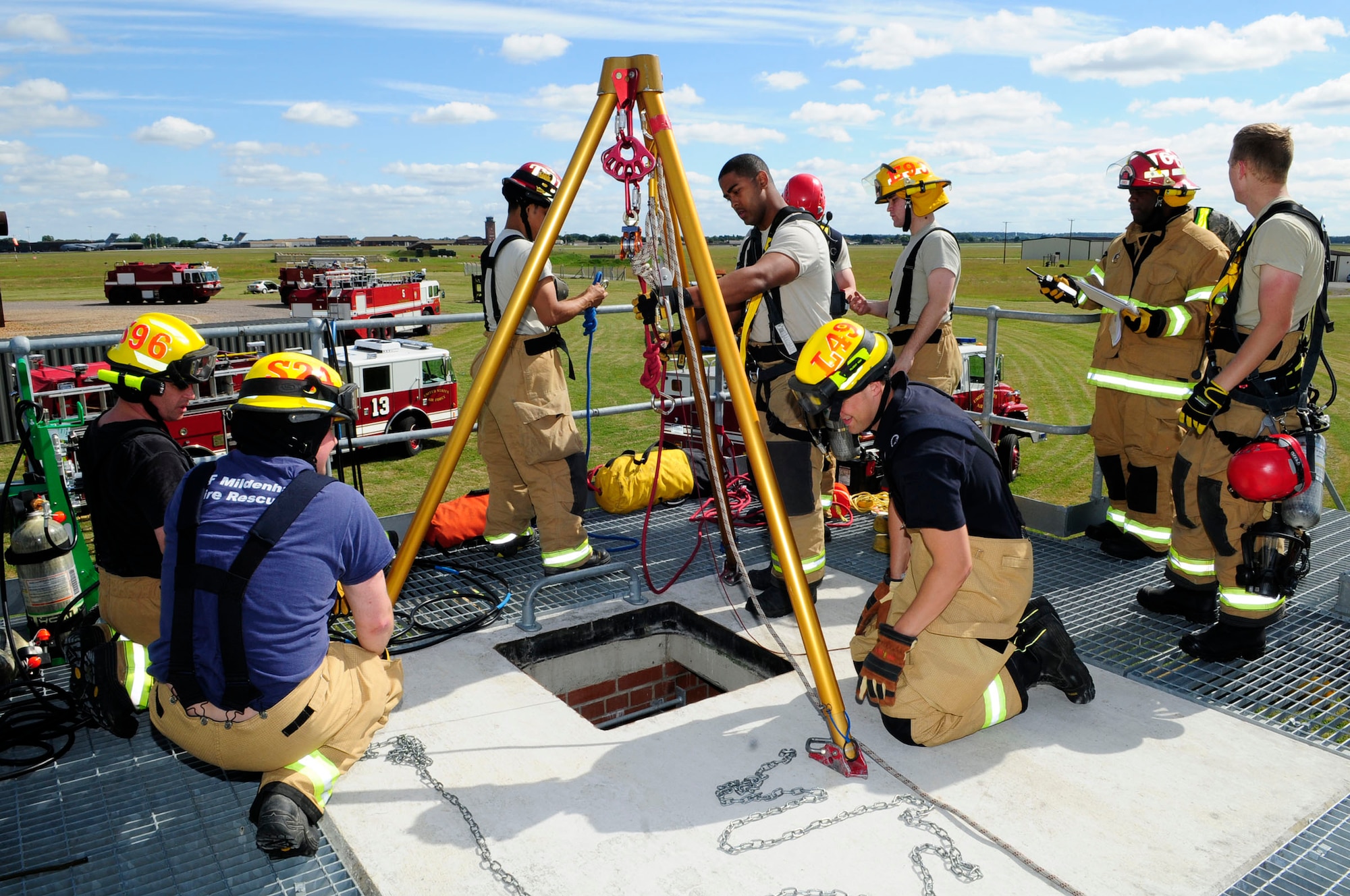 Firefighters from the 100th Civil Engineer Squadron Fire Department set up a tripod during confined space training June 26, 2014, on RAF Mildenhall, England. The training scenario involved a collapsed water pipe with a simulated child trapped inside. (U.S. Air Force photo/Karen Abeyasekere/Released)
