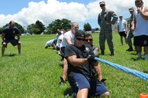 The 18th Civil Engineer Squadron firefighters participate in a tug-of-war match against members of the 18th Security Forces Squadron , Kadena Air Base, Japan, July 3, 2014. The tug-of-war match was part of the “Battle of the Badge” competition between 18th CES and 18th SFS.(U.S. Air Force photo by Airman 1st Class Stephen G. Eigel)  