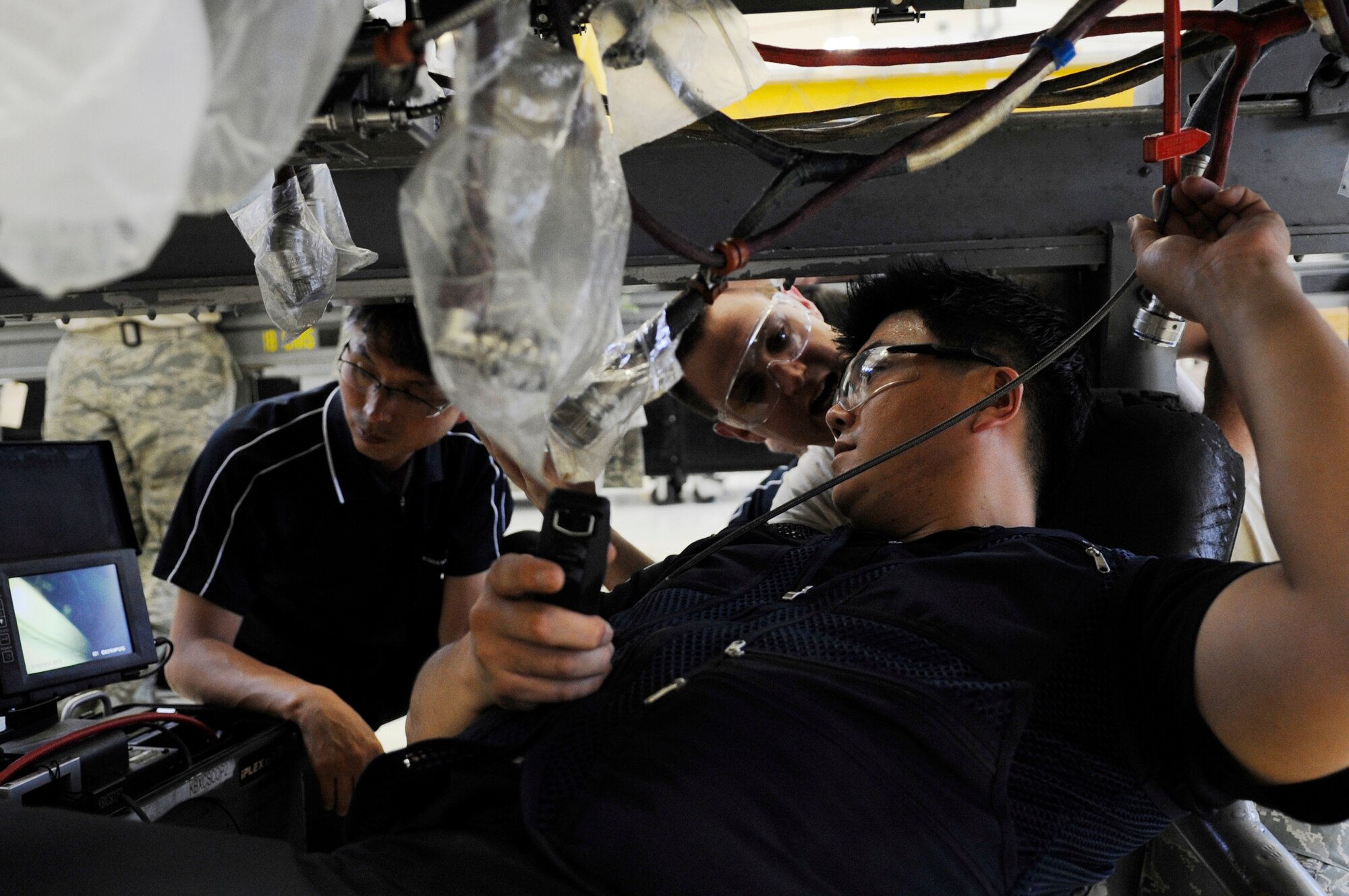 U.S. Air Force Tech. Sgt. Jeremiah Roper, 372nd Training Squadron, Detachment 15 propulsion systems instructor, trains Korean contractors on the proper use of a borescope to find defects inside aircraft engines on Kadena Air Base, Japan, July 3, 2014. The contractors went through a four-day course which gave them a one year certification to continue depot-level maintenance on F-15 Eagle and F-16 Fighting Falcon aircraft while at Gimhae Air Base, Republic of Korea. (U.S. Air Force photo by Senior Airman Marcus Morris)