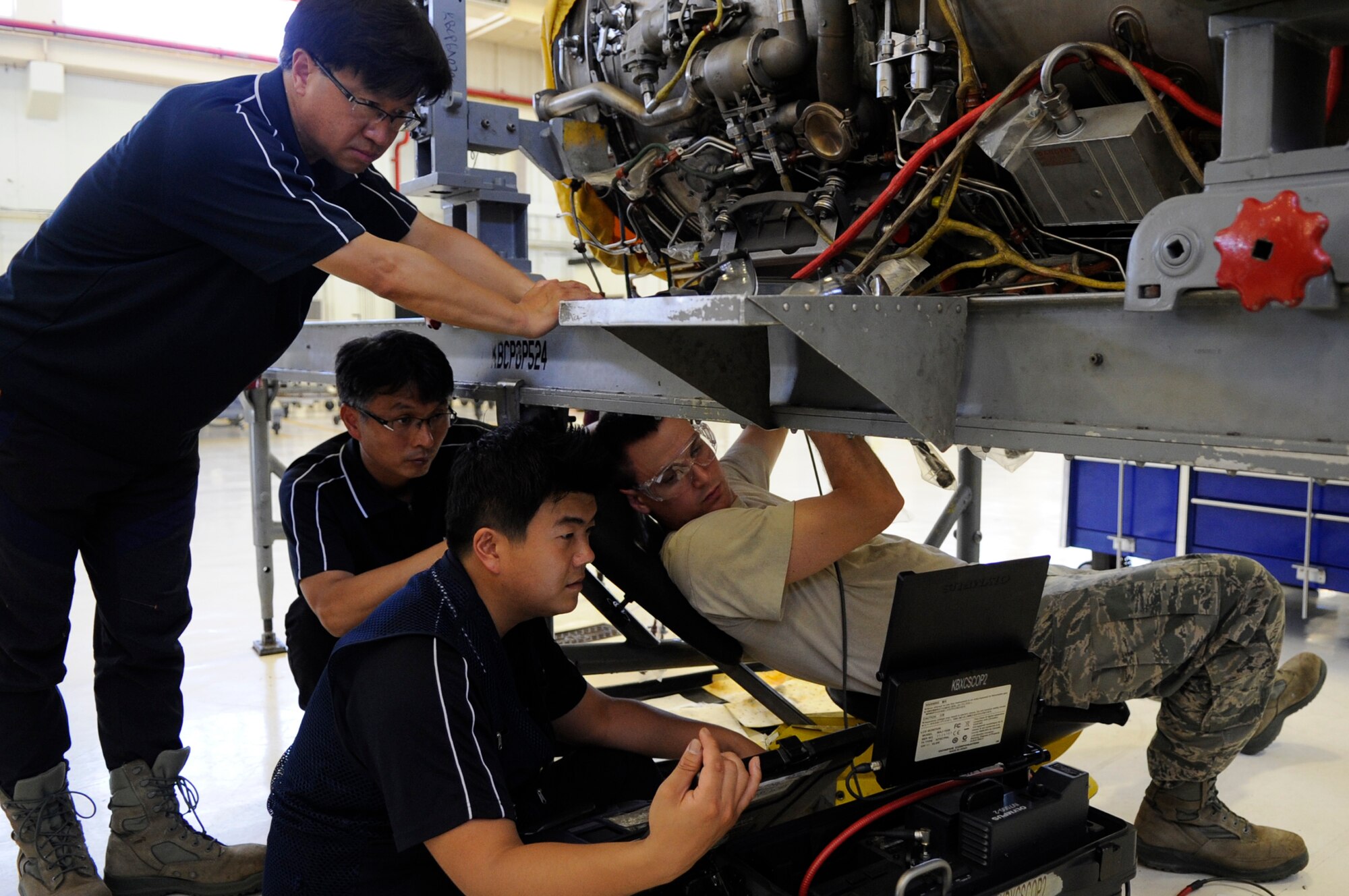 U.S. Air Force Tech. Sgt. Jeremiah Roper, 372nd Training Squadron, Detachment 15 propulsion systems instructor, trains Korean contractors on the proper use of a borescope to look for defects inside aircraft engines on Kadena Air Base, Japan, July 3, 2014. The contractors perform depot-level maintenance on F-15 Eagle and F-16 Fighting Falcon aircraft while at Gimhae Air Base, Republic of Korea. (U.S. Air Force photo by Senior Airman Marcus Morris)