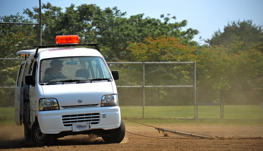 U.S. Air Force Airman 1st Class Blake Watkins, 35th Civil Engineer Squadron heavy equipment and pavements journeyman, uses a metal screen to brush the top soil on Leftwich Park’s baseball field at Misawa Air Base, Japan, July 2, 2014. Watkins drove in a circular motion throughout the entire field to help even out the sand. (U.S. Air Force photo/Senior Airman Jose L. Hernandez-Domitilo)