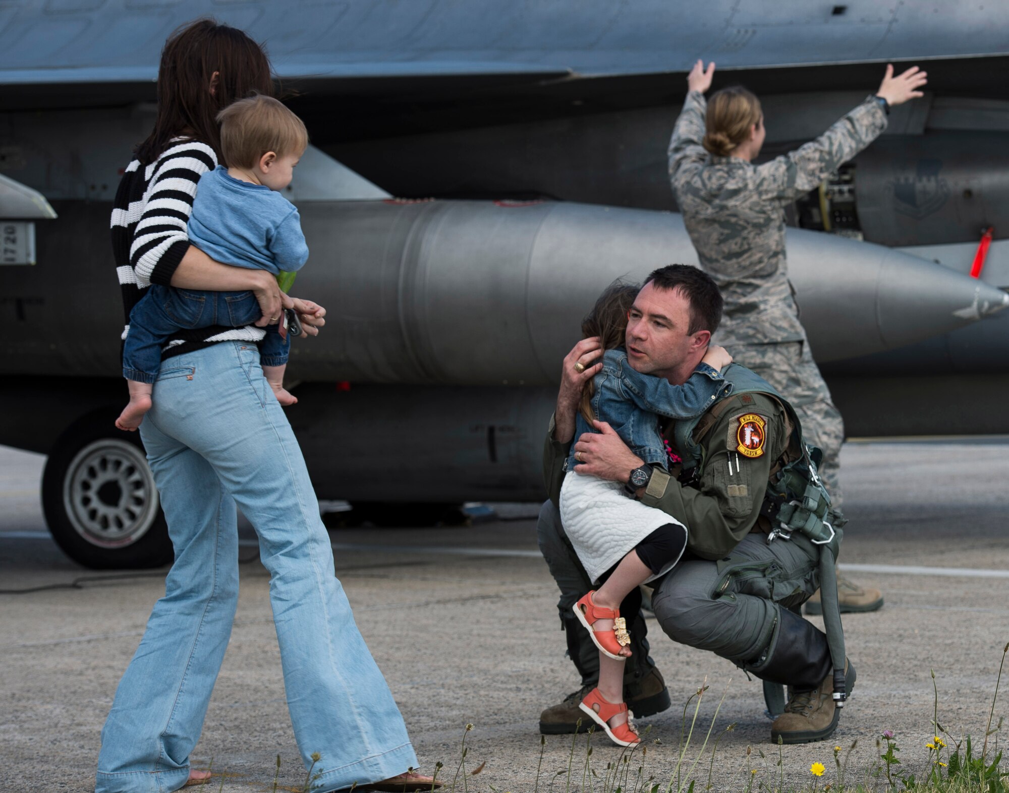 U.S. Air Force Maj. Jordan Hans, an F-16 Fighting Falcon fighter aircraft pilot assigned to the 52nd Fighter Wing, hugs his daughter Vivian on the flight line at Spangdahlem Air Base, Germany, June 30, 2014. Hans’ family greeted him upon his return from Poland where he participated in integrated training with NATO allies as a part of the U.S.’s efforts to ensure regional security. (U.S. Air Force photo by Staff Sgt. Chad Warren/Released)