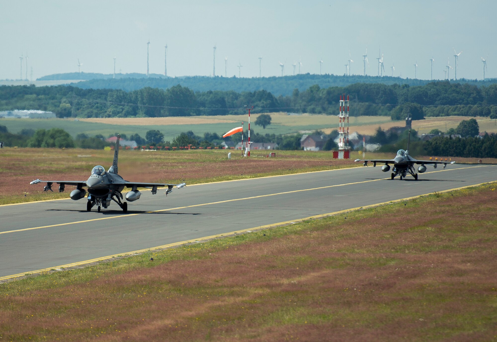 Two F-16 Fighting Falcon fighter aircraft assigned to the 52nd Fighter Wing taxi after landing at Spangdahlem Air Base, Germany, June 30, 2014. The aircraft returned from integrated training with NATO allies in Poland as part of the U.S.’s persistent presence mission in Eastern Europe. (U.S. Air Force photo by Staff Sgt. Chad Warren/Released)