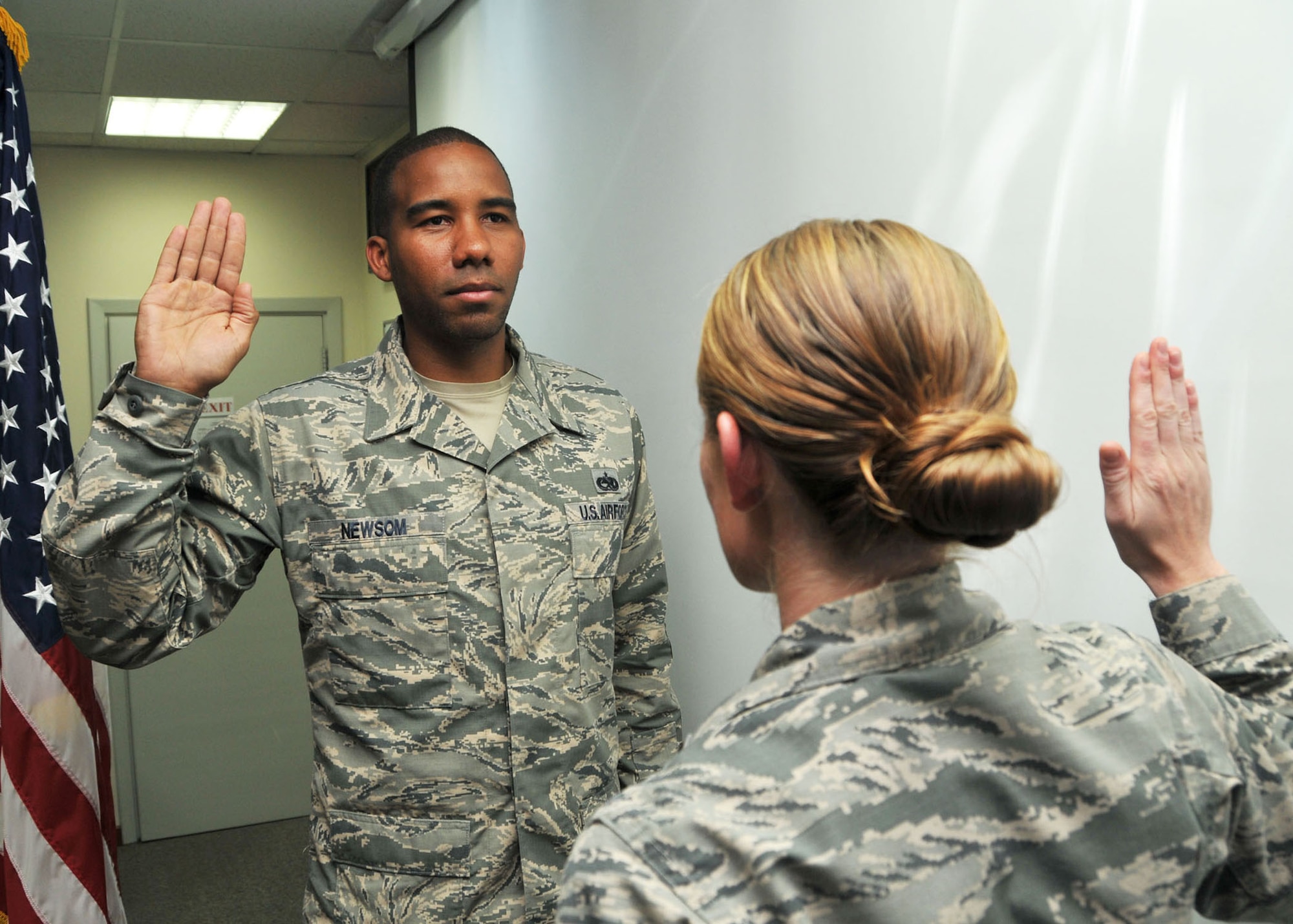 Air Force 2nd Lt. Christina Bausch administers the oath of enlistment to Air Force Staff Sgt. Michael Newsom, during his reenlistment ceremony at the 380th Air Expeditionary Wing at an undisclosed location in Southwest Asia June 27, 2014. (U.S. Air Force photo by Senior Master Sgt. Eric Peterson/Released) 