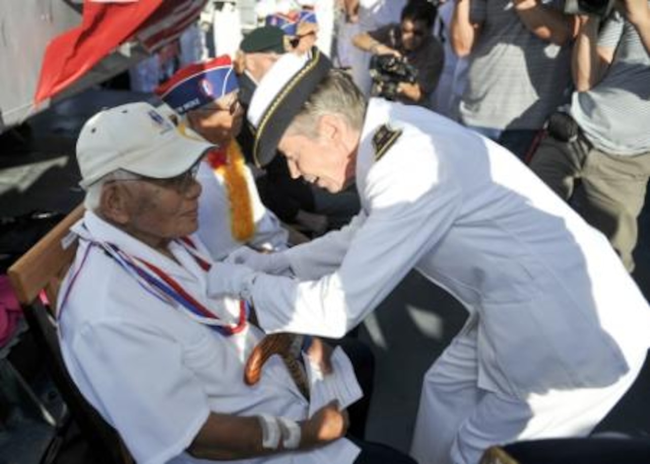Aboard the French Floréal-class frigate FS Prairial berthed in Pearl Harbor, Hawaii, Rear Adm. Anne Cullere, commander in chief of French forces in the Pacific, presents U.S. World War II veteran Shuji Akiyama, who’d fought with the 100th Battalion, the French Nation Order of the Legion of Honor during a July 2, 2014, ceremony in which six other veterans also received the honor. For more than a decade the government of France has presented the Legion of Honor to U.S. veterans who participated in the liberation of France during World War II. The ceremony took place during Rim of the Pacific, the world’s largest international maritime exercise. U.S. Navy photo by Petty Officer 1st Class David Kolmel