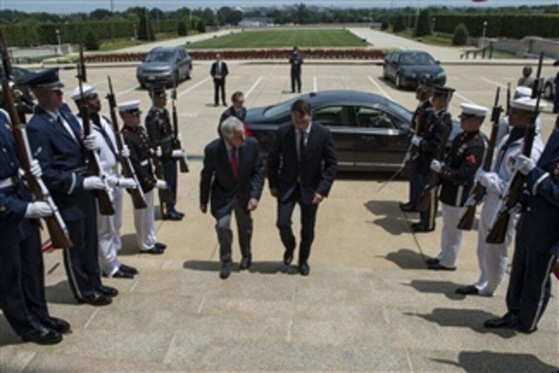 U.S. Defense Secretary Chuck Hagel welcomes Latvian Defense Minister Raimonds Vejonis in an honor cordon at the Pentagon, July 3, 2014. Hagel later commended Latvia's progress toward increasing defense spending. 