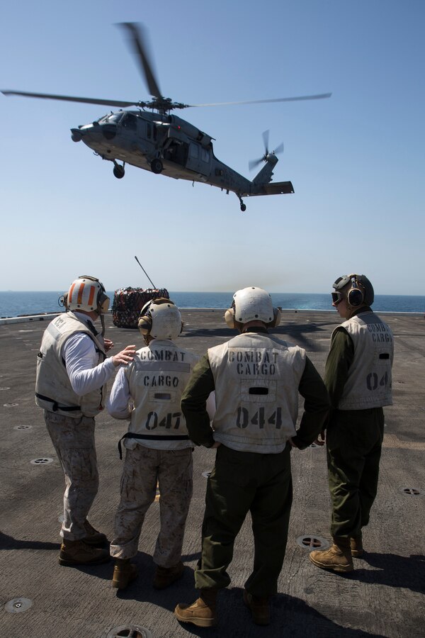 U.S. 5TH FLEET AREA OF RESPONSIBILITY (June 27, 2014) U.S. Marines with the 22nd Marine Expeditionary Unit’s (MEU) combat cargo section prepare to move cargo as an MH-60S Seahawk with Helicopter Sea Combat Squadron 9 (HSC 9) drops several pallets onto the amphibious transport dock ship USS Mesa Verde (LPD 19) during a replenishment at sea. The 22nd MEU is deployed with the Bataan Amphibious Ready Group as a theater reserve and crisis response force throughout U.S. Central Command and the U.S. 5th Fleet area of responsibility. (U.S. Marine Corps photo by Cpl. Manuel A. Estrada/ Released)