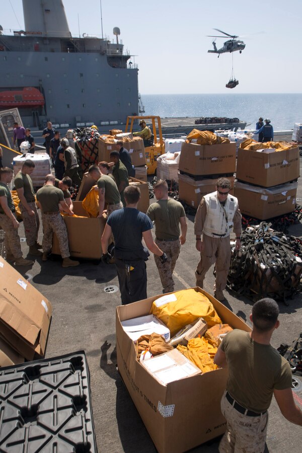 U.S. 5TH FLEET AREA OF RESPONSIBILITY (June 27, 2014) U.S. Marines with 22nd Marine Expeditionary Unit (MEU) and U.S. Navy Sailors with the amphibious transport dock ship USS Mesa Verde (LPD 19) sort cargo and mail as an MH-60S Seahawk with Helicopter Sea Combat Squadron 9 (HSC 9) lifts more pallets from the USNS Joshua Humphreys (T-AO 188) during a replenishment at sea aboard the Mesa Verde. The 22nd MEU is deployed with the Bataan Amphibious Ready Group as a theater reserve and crisis response force throughout U.S. Central Command and the U.S. 5th Fleet area of responsibility. (U.S. Marine Corps photo by Cpl. Manuel A. Estrada/Released)