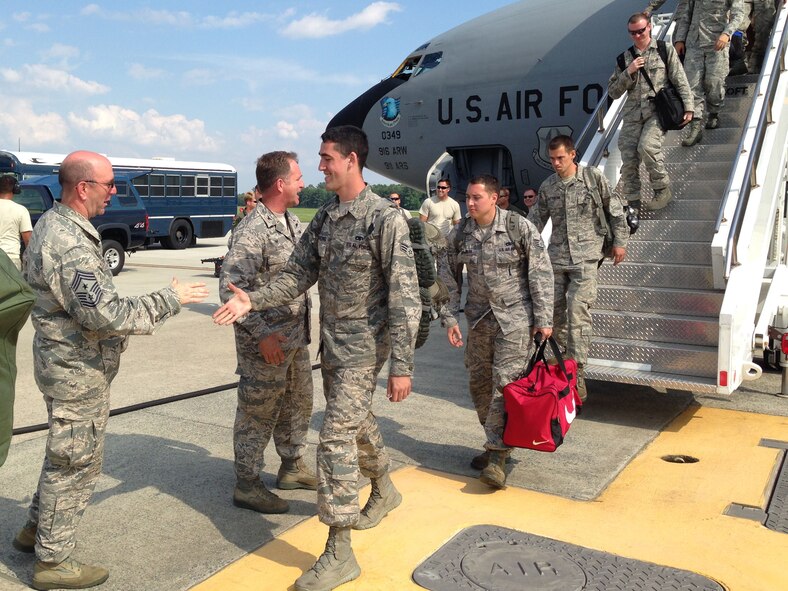 Chief Master Sgt. Jeffrey Craver (far left), 4th Fighter Wing command chief, and Col. Mark Slocum (middle), 4th FW commander, greet Airmen on the flight line July 4, 2014, at Seymour Johnson Air Force Base, North Carolina. More than 200 support personnel were flown to Wright Patterson AFB, Ohio, July 3, 2014, to support F-15E Strike Eagle repositioning due to Hurricane Arthur. (Courtesy photo/Col. Lamar Pettus)
