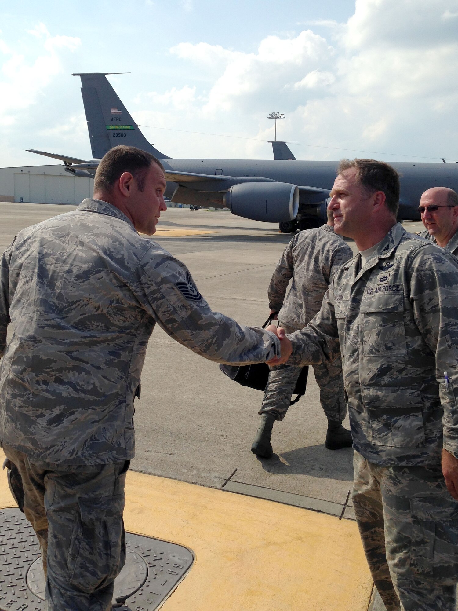 Col. Mark Slocum (right), 4th Fighter Wing commander, greets an Airman on the flight line July 4, 2014, at Seymour Johnson Air Force Base, North Carolina. More than 200 support personnel were flown to Wright Patterson AFB, Ohio, July 3, 2014, to support F-15E Strike Eagle repositioning due to Hurricane Arthur. (Courtesy photo/Col. Lamar Pettus)