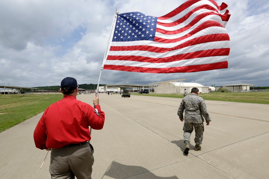 Local military supporter Dave Burns waves an American flag for 188th Wing members following their Conversion Day ceremony and the departure of their final two A-10C Thunderbolt II “Warthogs” June 7, 2014. Burns often posts near the flightline and waves an American flag to showcase his support. (National Guard photo by Senior Master Sgt. Dennis Brambl/188th Fighter Wing Public Affairs)