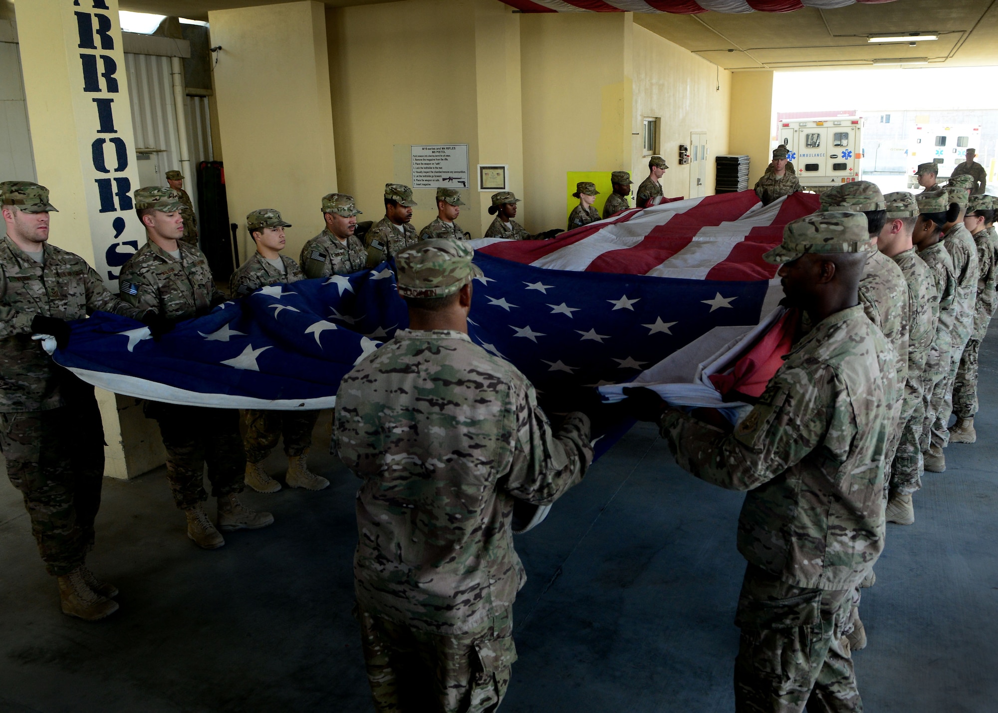 U.S. Air Force Airmen fold an American flag during a folding ceremony at Craig Joint Theater Hospital in Bagram Airfield, Afghanistan July 4, 2014.  The Airmen replaced a 20 by 30 foot flag that hung on the ceiling of main patient entry area of the hospital also known as “Warrior’s Way.”  A newly dedicated American flag was given to the hospital by a group of donors in the U.S. (U.S. Air Force photo by Staff Sgt. Evelyn Chavez/Released)