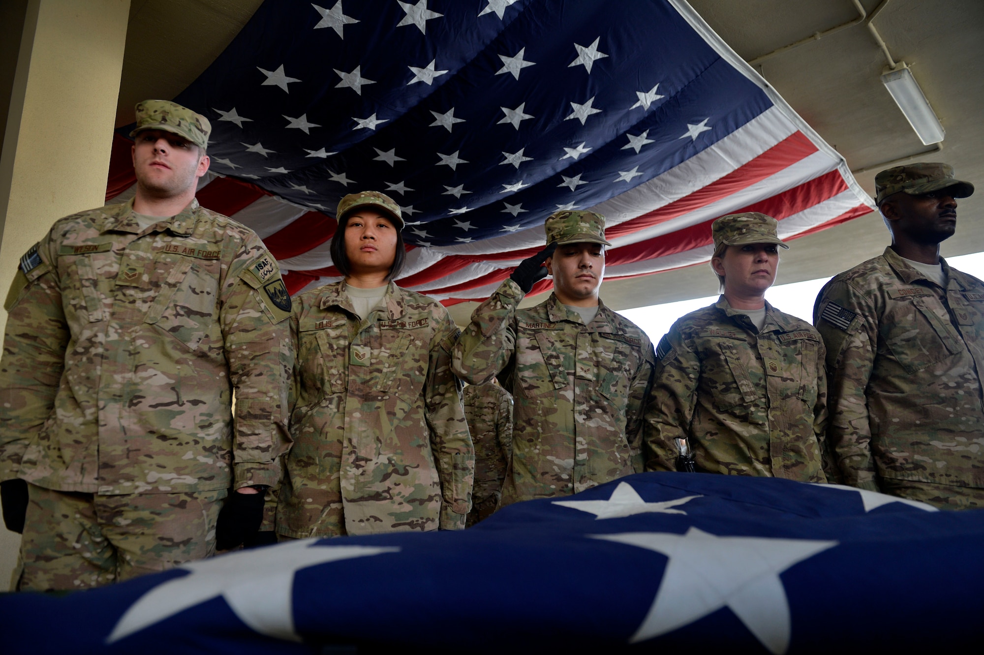 U.S. Air Force Airmen honor an American flag during a folding ceremony at Craig Joint Theater Hospital in Bagram Airfield, Afghanistan July 4, 2014.  The retired flag was replaced by a newly donated flag which was unfolded on the steps of the Capitol building with members of the U.S. House of Representatives Veterans’ Affairs committee and brought to the 9/11 Memorial.  (U.S. Air Force photo by Staff Sgt. Evelyn Chavez/Released)