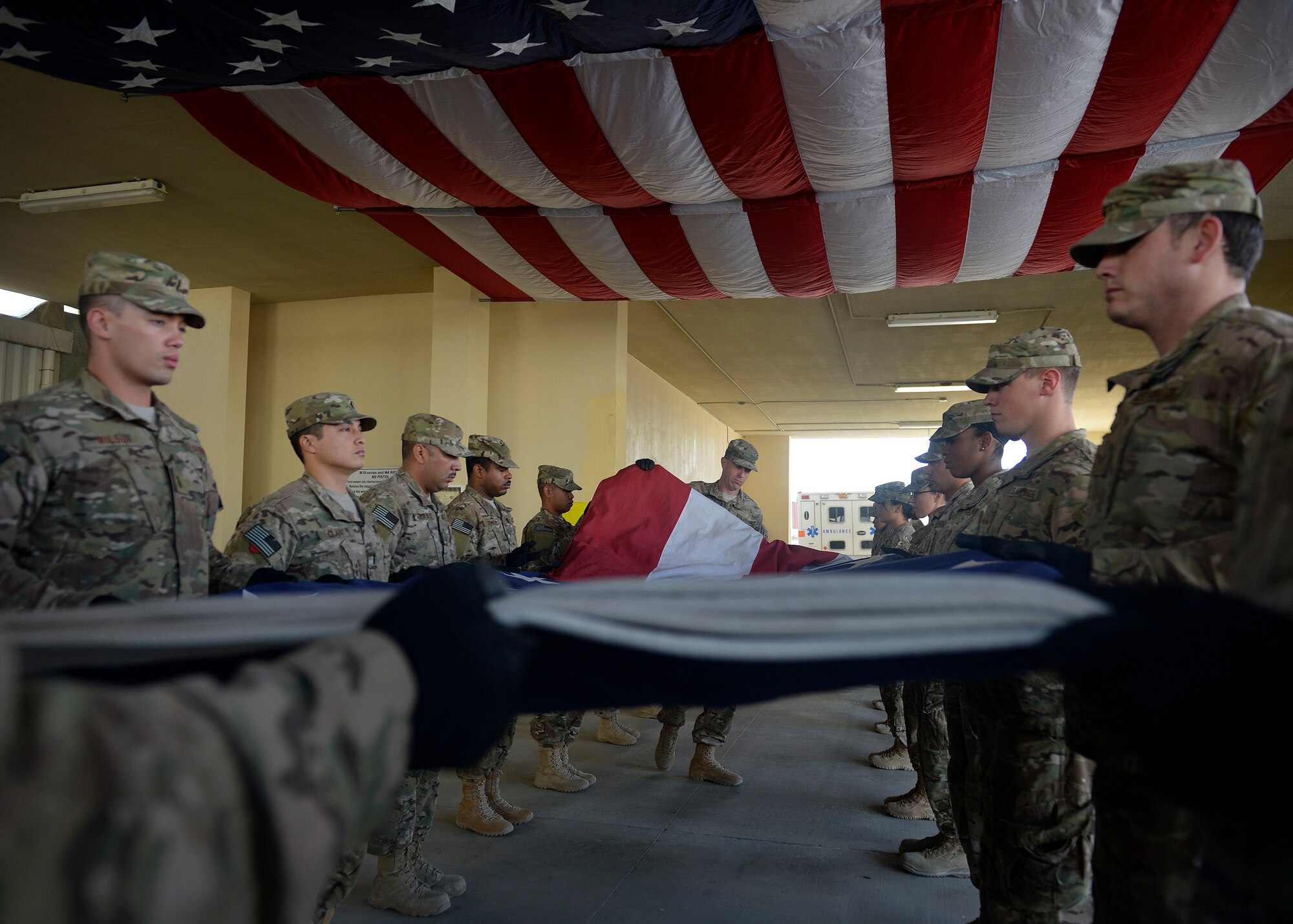 U.S. Air Force Airmen fold an American flag during a folding ceremony at Craig Joint Theater Hospital in Bagram Airfield, Afghanistan July 4, 2014.  The Airmen replaced a 20 by 30 foot flag that hung on the ceiling of the main patient entry area of the hospital also known as “Warrior’s Way.”  A newly dedicated American flag was given to the hospital by a group of donors in the U.S. (U.S. Air Force photo by Staff Sgt. Evelyn Chavez/Released)