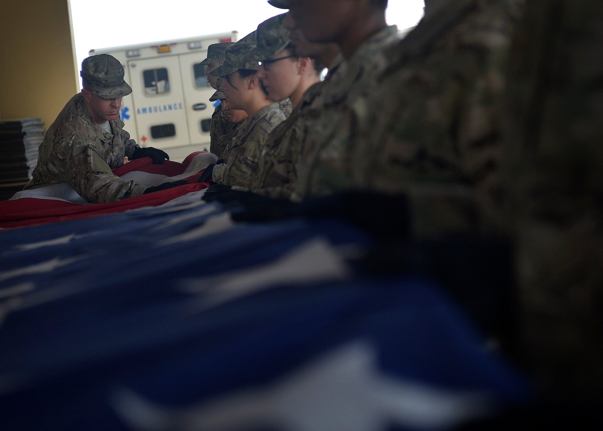 U.S. Air Force Staff Sgt. Jason Jones, 455th Expeditionary Medical Support Squadron, folds an American flag during a folding ceremony at Craig Joint Theater Hospital in Bagram Airfield, Afghanistan July 4, 2014.  A newly dedicated American flag replaced the hospital’s retired flag which was first raised on July 4, 2011.  The new flag hangs on the ceiling of the hospital’s main patient entry also known as “Warriors Way.” Jones is deployed from Keesler Air Force Base, Miss. and a native of Tampa Bay, Fla. (U.S. Air Force photo by Staff Sgt. Evelyn Chavez/Released)
