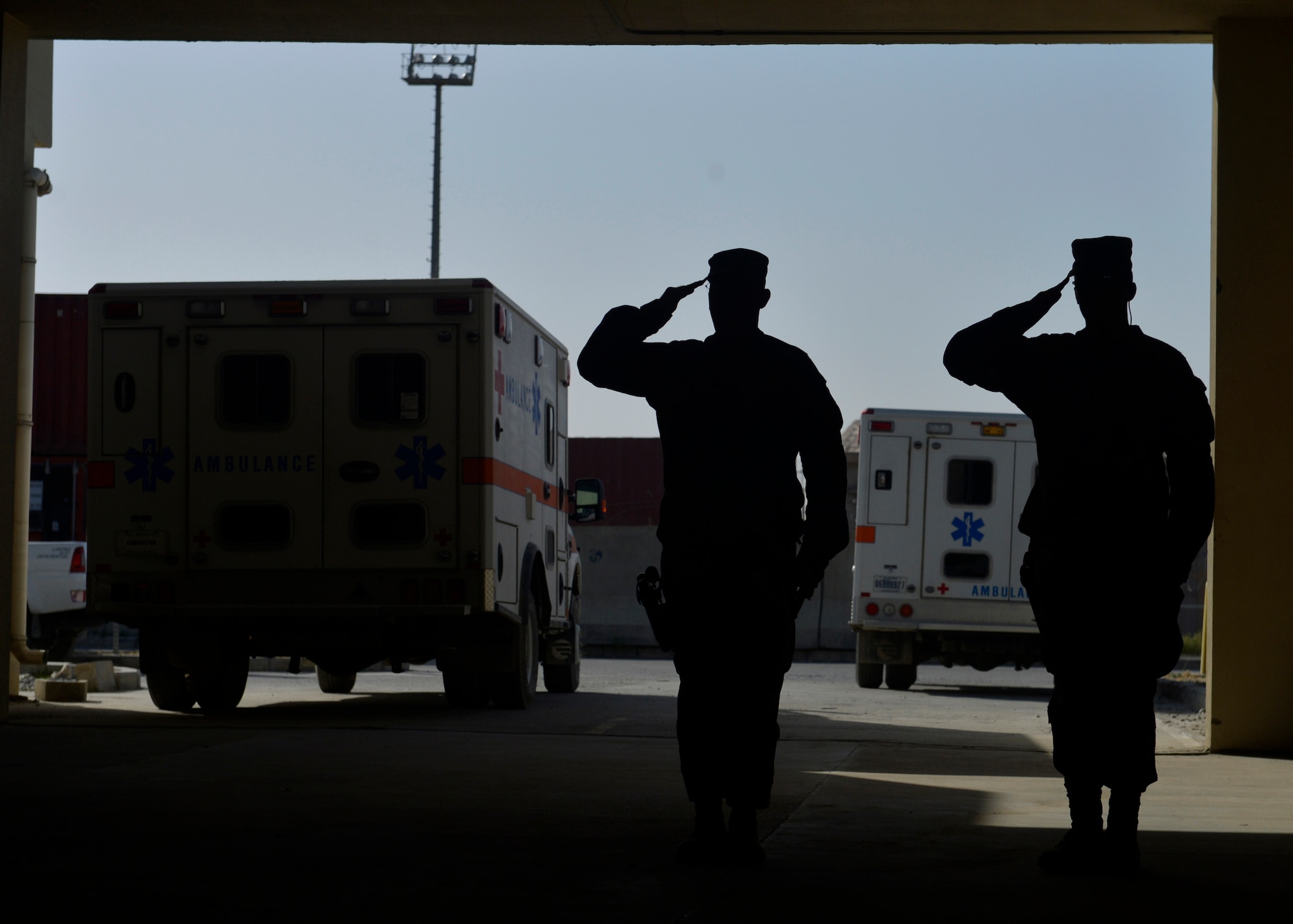 U.S. Air Force Airmen salute during a flag folding ceremony at Craig Joint Theater Hospital in Bagram Airfield, Afghanistan July 4, 2014.  The Airmen replaced a 20 by 30 foot flag that hung on the ceiling of the main patient entry area of the hospital also known as “Warrior’s Way.”  A newly dedicated American flag was given to the hospital by a group of donors in the U.S. (U.S. Air Force photo by Staff Sgt. Evelyn Chavez/Released)