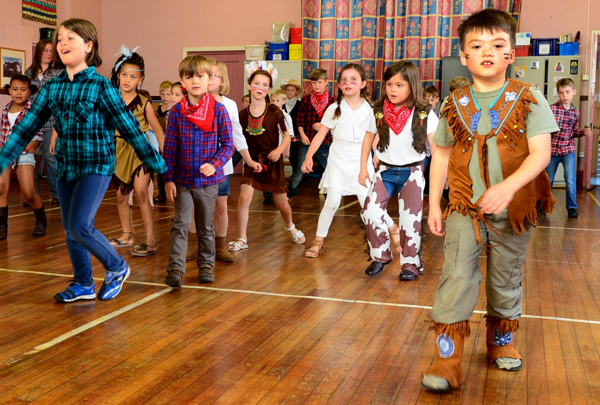Year two students, the U.K. equivalent to 1st grade, learn how to do the Cha Cha slide, a popular American line dance, during American Week at Guildhall Feoffment Primary School, in Bury St. Edmunds, July 2, 2014. Students participated in various hands-on activities to learn about American history. (U.S. Air Force photo by Airman 1st Class Dawn M. Weber/Released)
