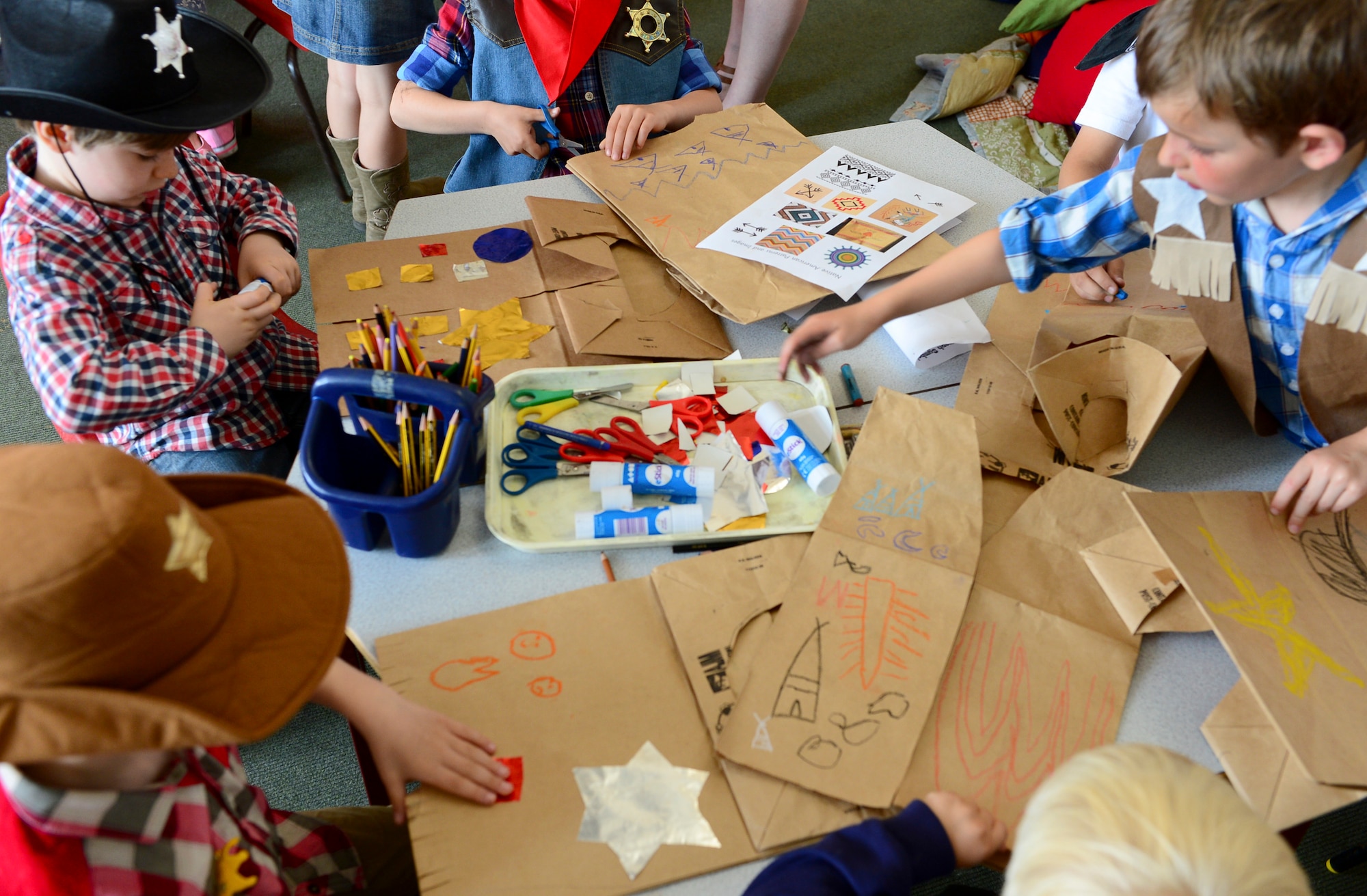 Year one students, the U.K. equivalent of kindergartners, dressed as cowboys and Indians, draw Native American patterns and images to learn about early U.S. history during America Week, July 2, 2014. Students from Guildhall Feoffment Primary School, in Bury St. Edmunds, participated in various hands-on activities to learn about American history. (U.S. Air Force photo by Airman 1st Class Dawn M. Weber/Released)