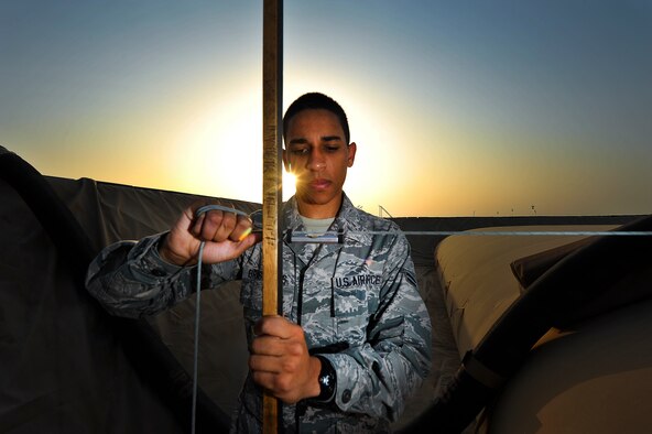 Airman 1st Class Isiah Brashears, a 380th Expeditionary Logistics Readiness Squadron fuels storage technician, checks the levels of fuel storage bladders June 29, 2014, at an undisclosed location in Southwest Asia. Brashears, deployed from Elmendorf Air Force Base, Ak., has been recognized as a 380th Air Expeditionary Wing warrior of the week. (U.S. Air Force photo by Tech. Sgt. Russ Scalf/Released)
