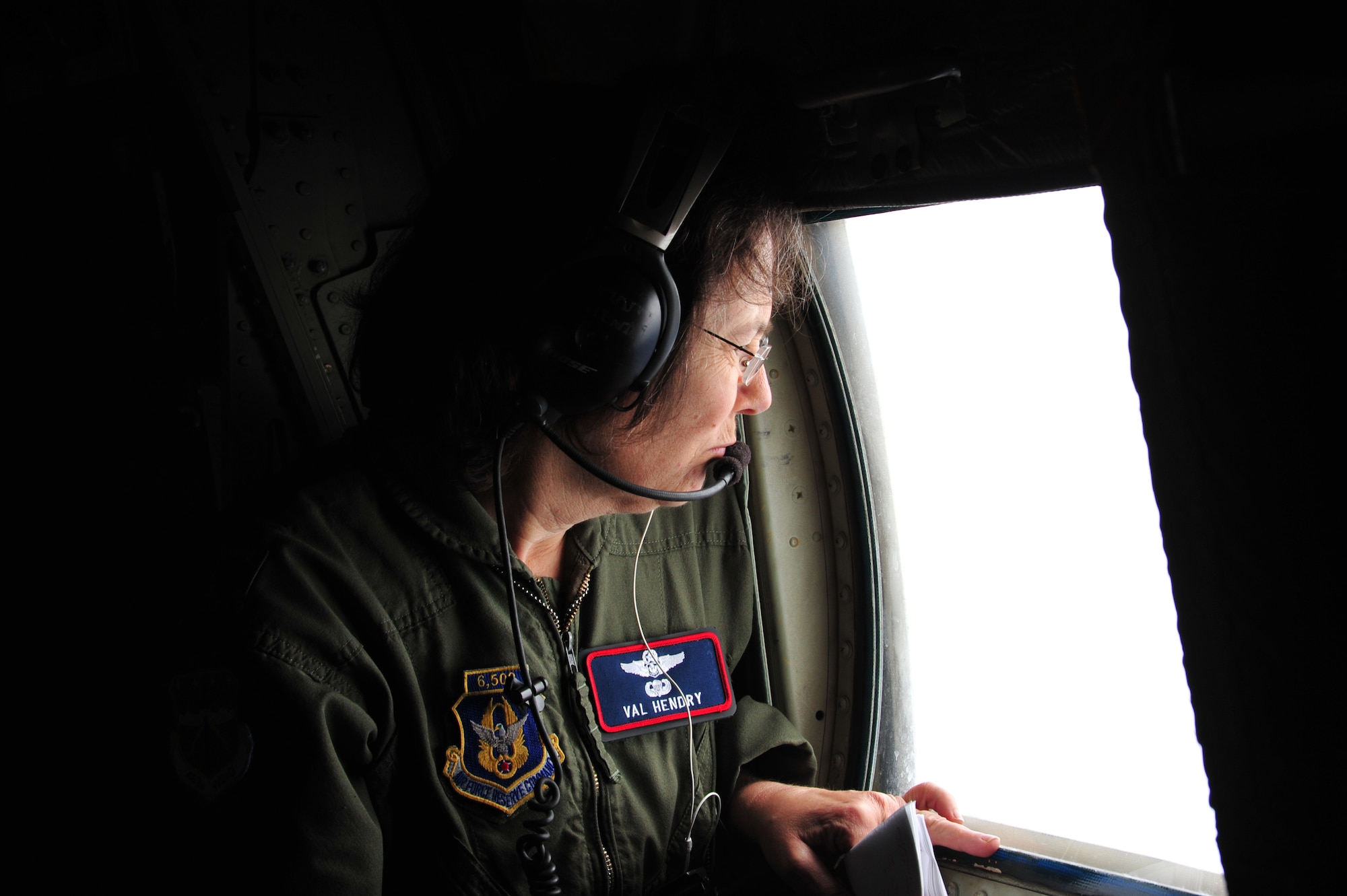 Lt Col. Val Hendry, 53rd Weather Reconnaissance Squadron Aerial Reconnaissance Weather Officer, visually inspects the amount of sea foam on the ocean surface to assist in determining wind speeds while flying through Tropical Storm Arthur July 1 2014. Hendry was performing this function in addition to the data collected by the Stepped Frequency Microwave Radiometer, which measures wind speeds on the ocean surface. Before the SFMRs were used by the Hurricane Hunters, the weather officers mainly relied on visual inspections of the surface to determine wind speeds. (U.S. Air Force photo/Master Sgt. Brian Lamar)
