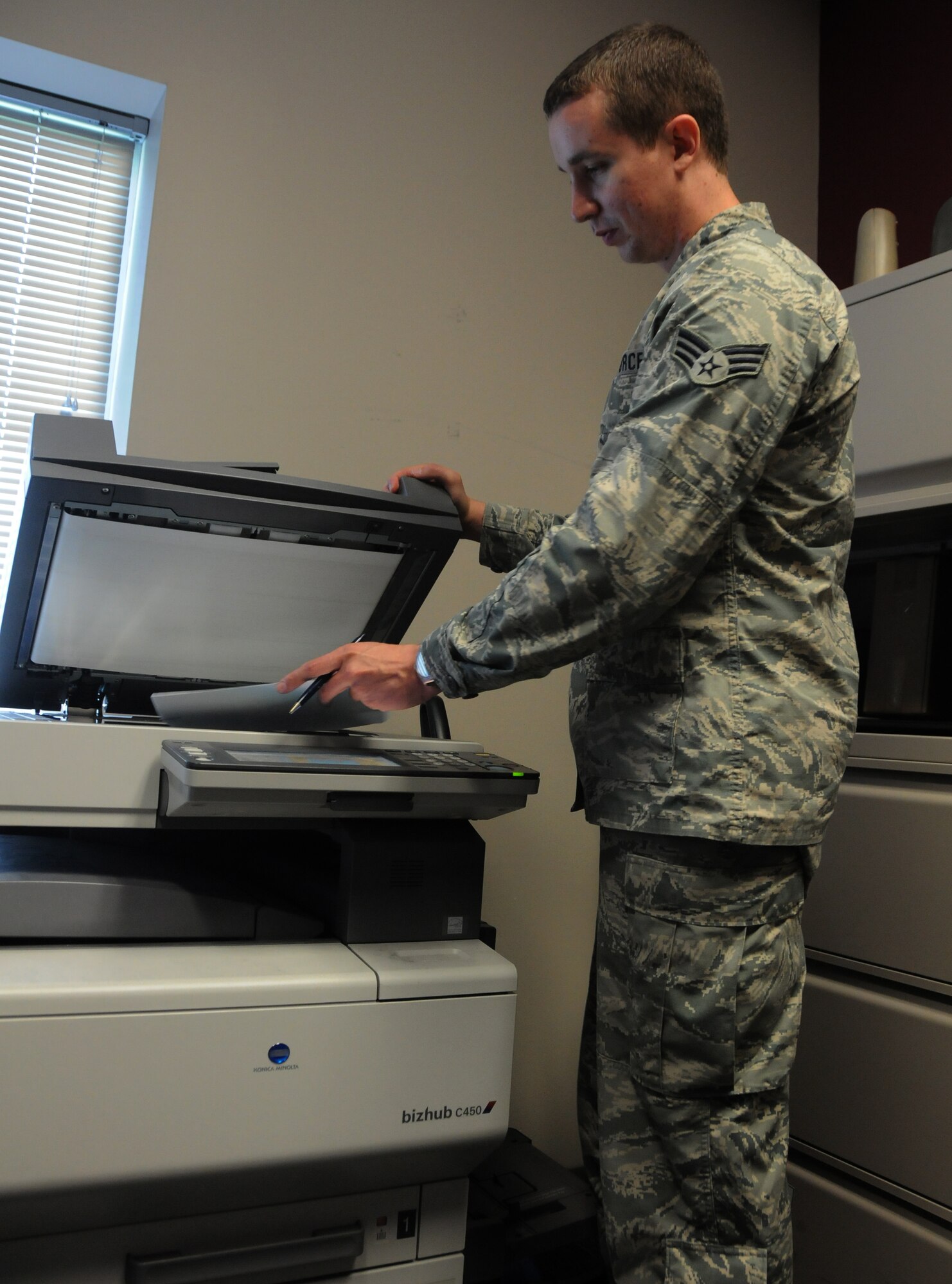 Senior Airman Matthew Bugg, a financial management technician with the 188th Comptroller Flight, makes a copy of a travel voucher at Ebbing Air National Guard Base, Fort Smith, Arkansas, July 1, 2014. Bugg was selected as the 188th Wing’s The Flying Razorback Spotlight for July 2014. (U.S. Air National Guard photo by Airman 1st Class Cody Martin)
