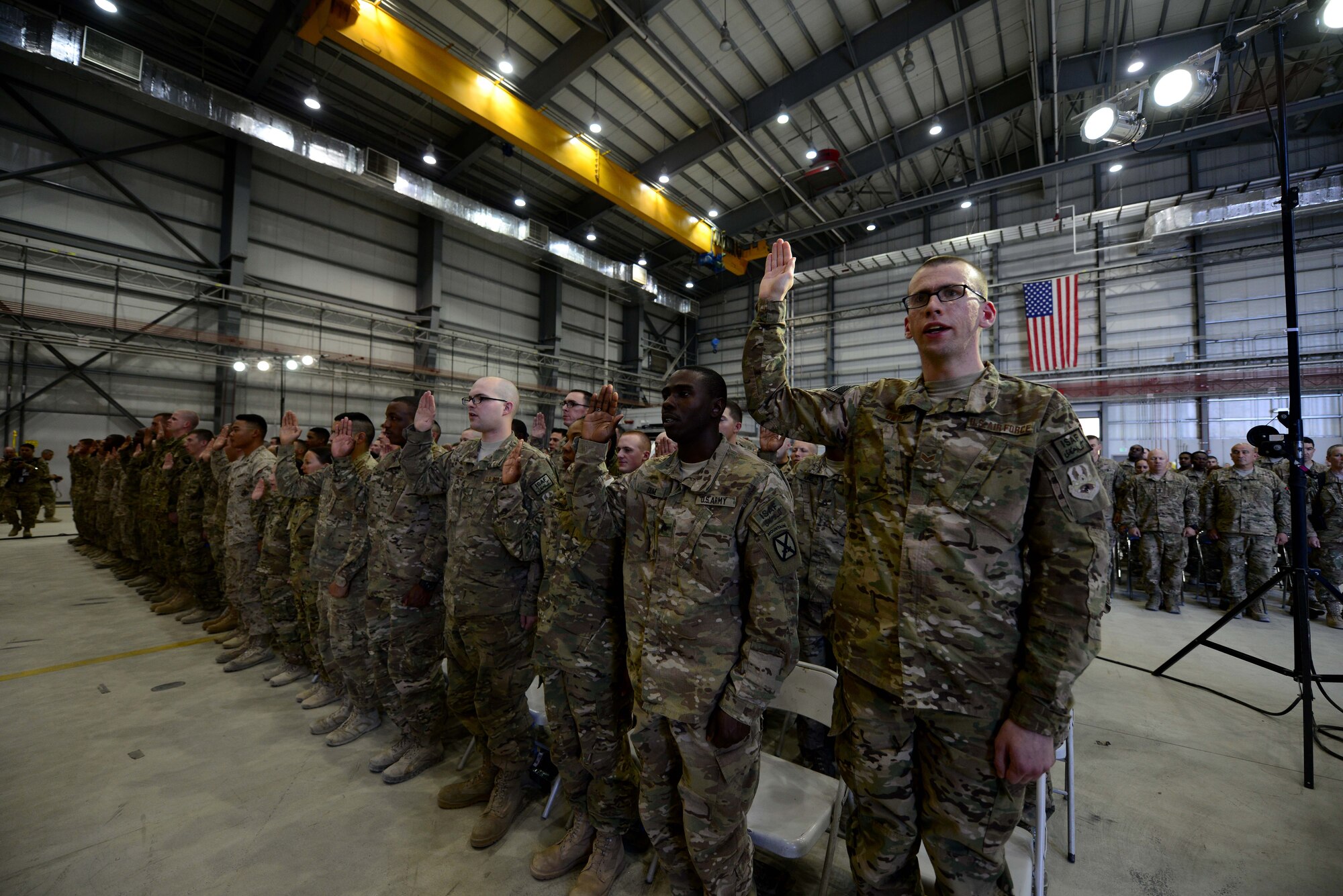 U.S. service members receive the oath of enlistment during a reenlistment ceremony during a Fourth of July celebration at Bagram Airfield, Afghanistan July 4, 2014.  The event was a team effort by the U.S. Air Force and Army to entertain all service members.  (U.S. Air Force photo by Staff Sgt. Evelyn Chavez/Released)